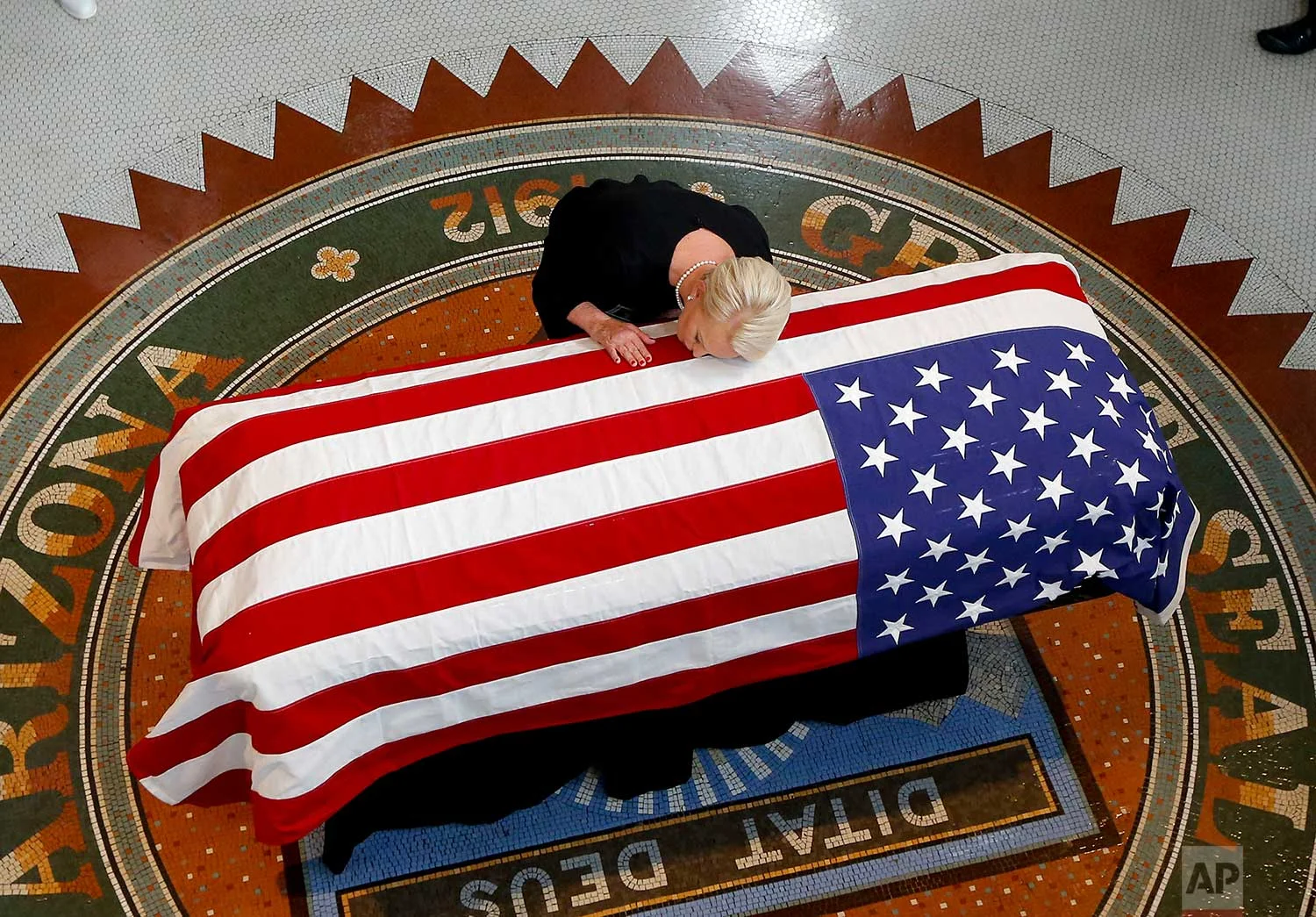 Cindy McCain, wife of, Sen. John McCain, R-Ariz. lays her head on casket during a memorial service at the Arizona Capitol on Wednesday, Aug. 29, 2018, in Phoenix. (AP Photo/Ross D. Franklin, Pool)
