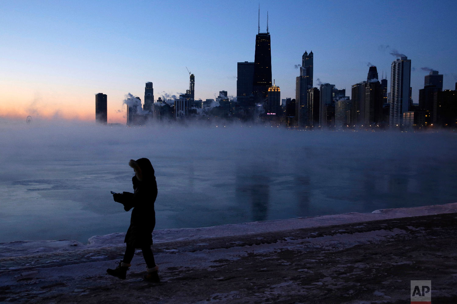  A person walks along the lakeshore, Wednesday, Jan. 30, 2019, in Chicago. (AP Photo/Kiichiro Sato) 