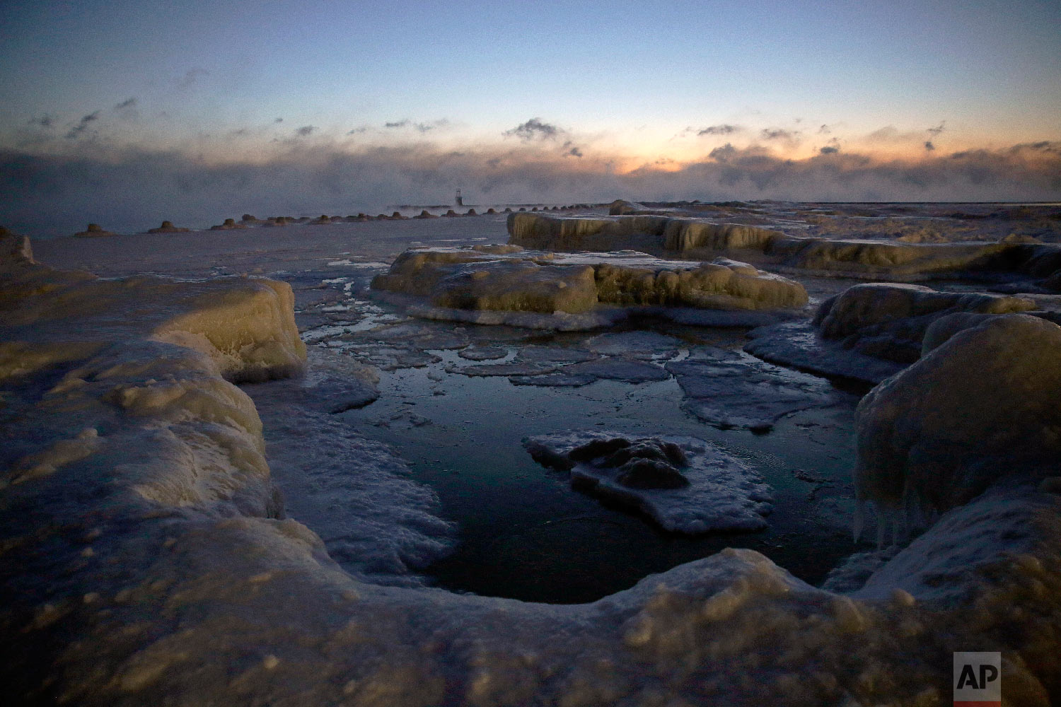  Ice forms along the shore of Lake Michigan before sunrise, Wednesday, Jan. 30, 2019, in Chicago. (AP Photo/Kiichiro Sato) 