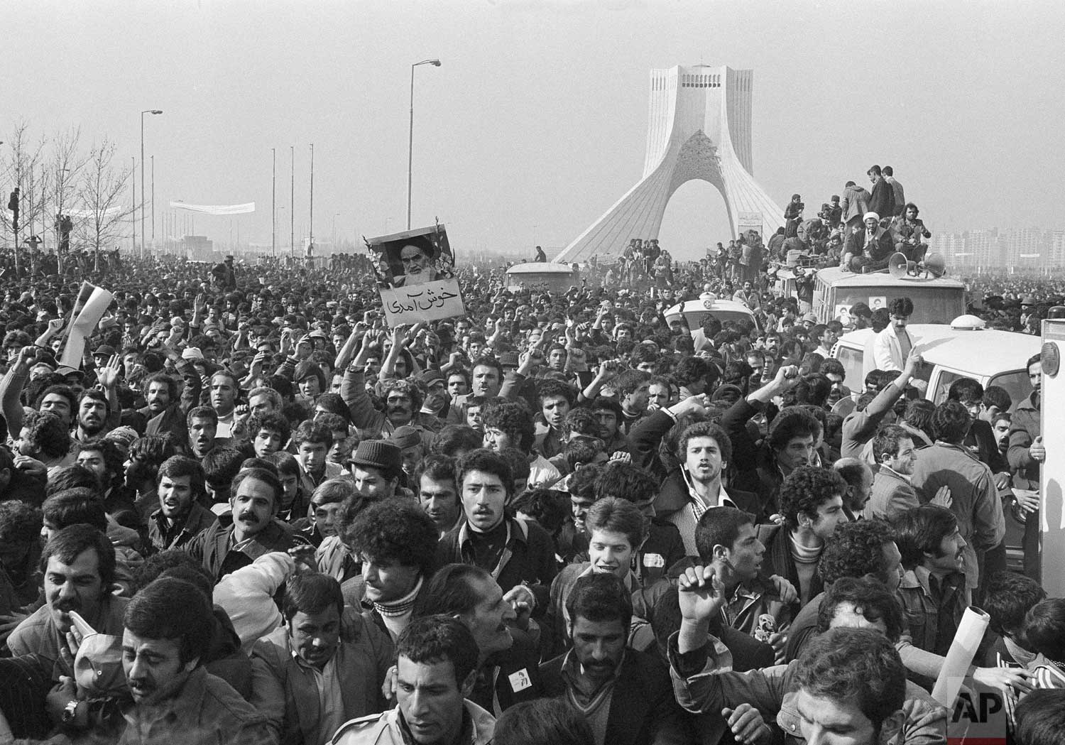  In this Feb. 1, 1979 photo, the motorcade of Ayatollah Ruhollah Khomeini is lost among the throngs of supporters at the Shayad, a landmark memorial to the shah, near the airport in Tehran, Iran. (AP Photo/FY) 