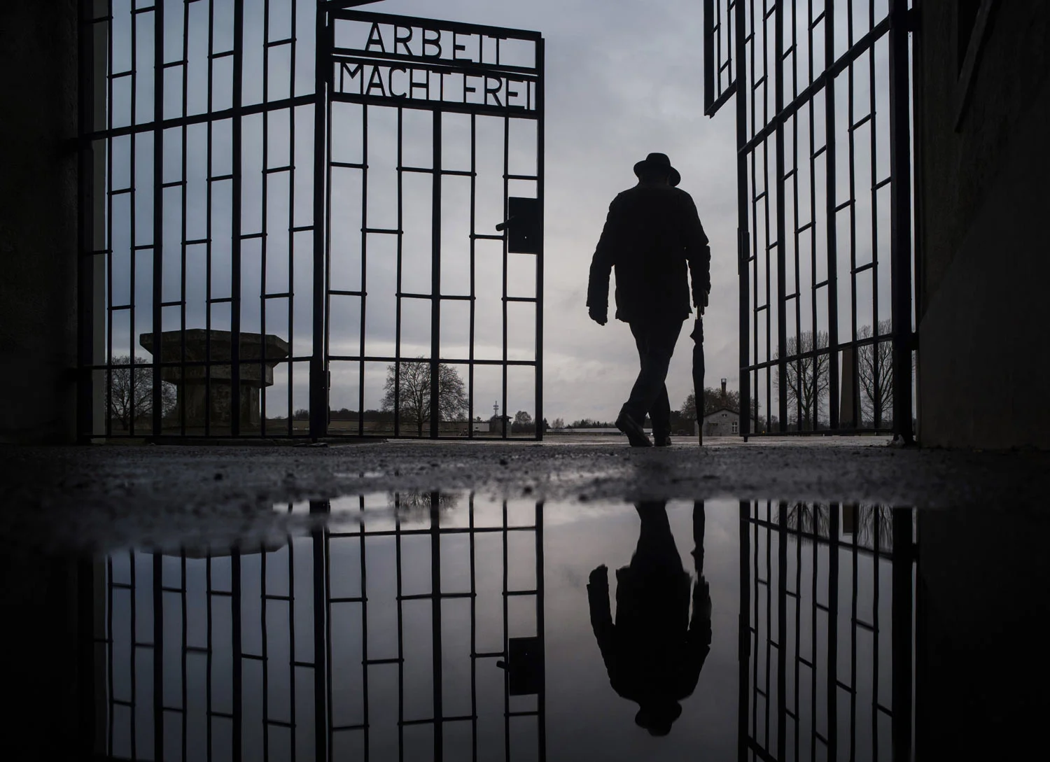 A man walks through the gate of the Sachsenhausen Nazi death camp with the phrase 'Arbeit macht frei' (work sets you free) during International Holocaust Remembrance Day in Oranienburg, about 30 kilometers (18 miles), north of Berlin, Germany, on Su