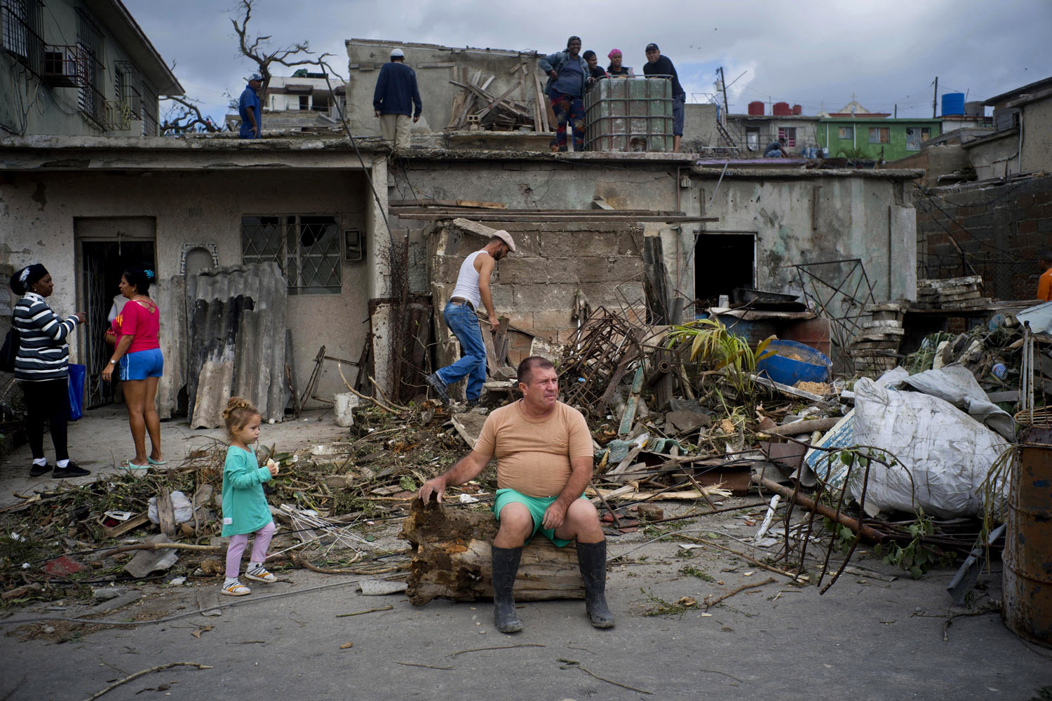 A man rests on the trunk of a tree that was toppled by a tornado, after removing rubble from his home in Regla, Cuba, on Monday, Jan. 28, 2019. A tornado and pounding rains smashed into the eastern part of Cuba's capital overnight, toppling trees, bending power poles and flinging shards of metal roofing through the air as the storm cut a path of destruction across eastern Havana. (AP Photo/Ramon Espinosa)