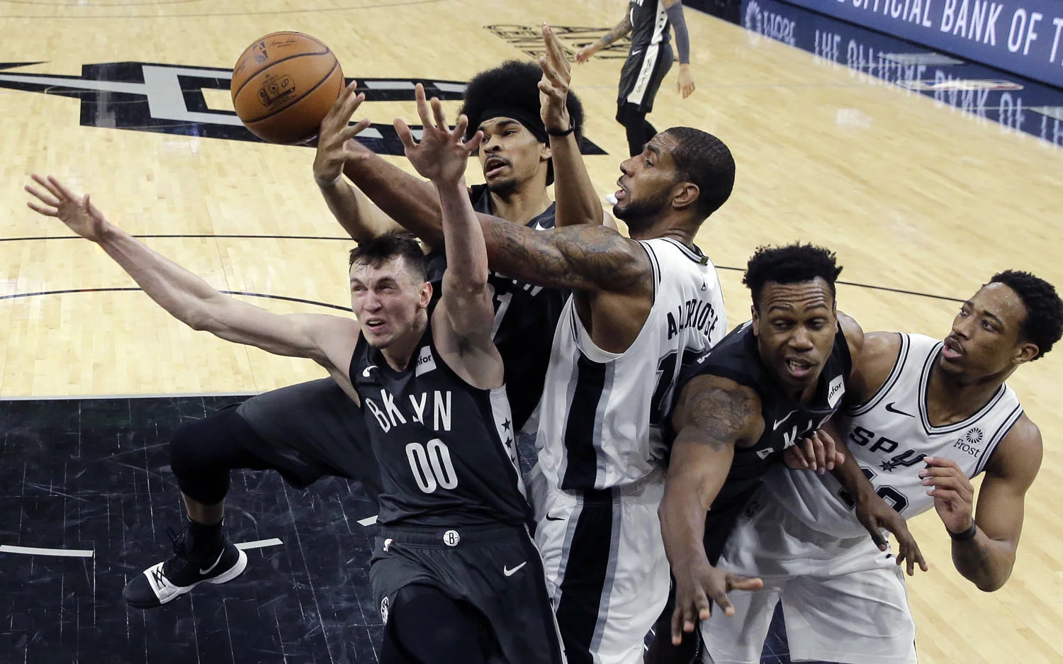 San Antonio Spurs center LaMarcus Aldridge (12) battles Brooklyn Nets forward Rodions Kurucs (00) and center Jarrett Allen, second from left, for a rebound during the second half of an NBA basketball game, in San Antonio, Thursday, Jan. 31, 2019. Sa