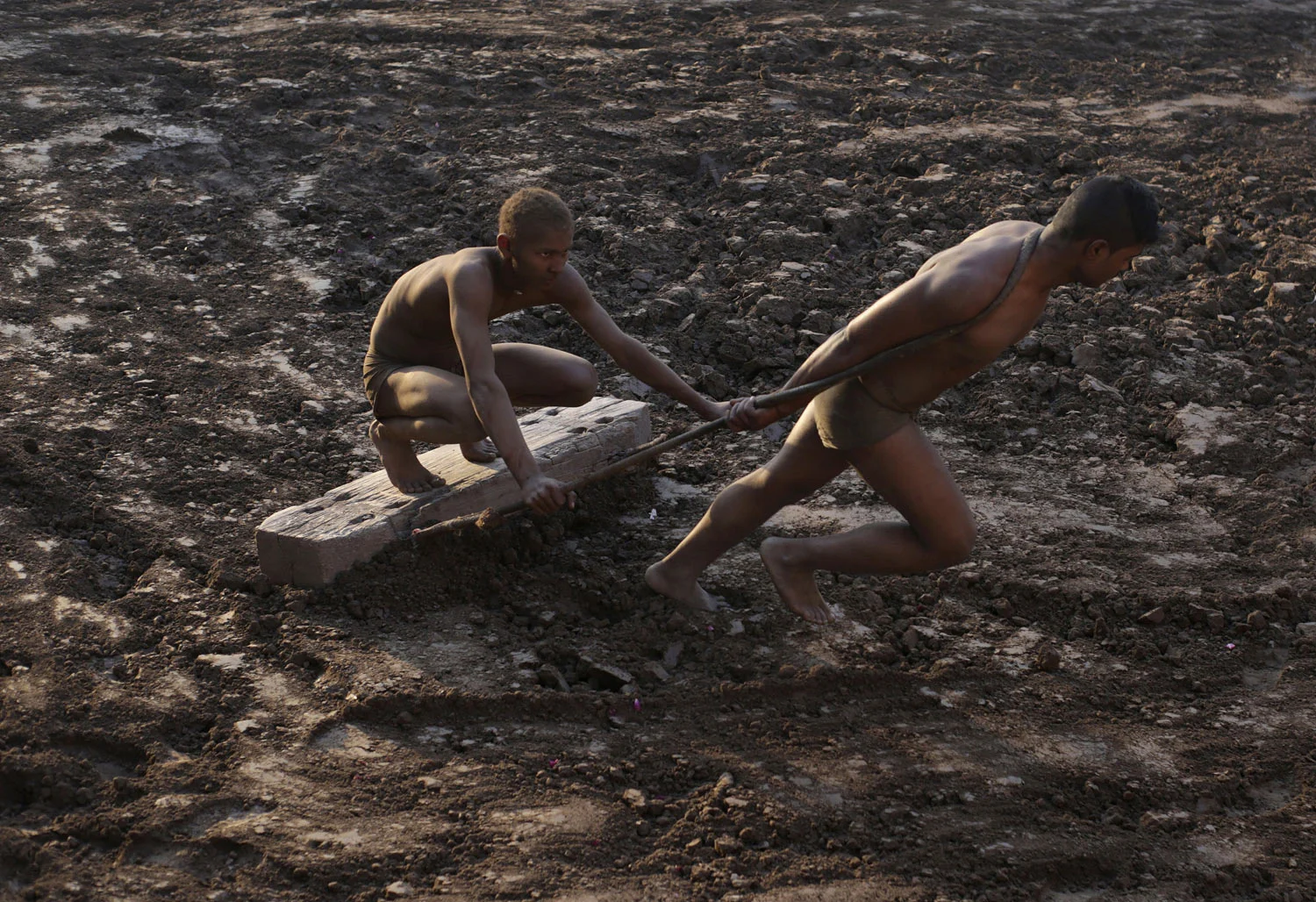 Wrestlers prepare the ground as part of their training for the national sport of Kushti, in Lahore, Pakistan, Monday, Jan. 28, 2019. Kushti, also known as Pehlwani, is a several thousand year-old sport and is practiced in the Indian subcontinent. Th