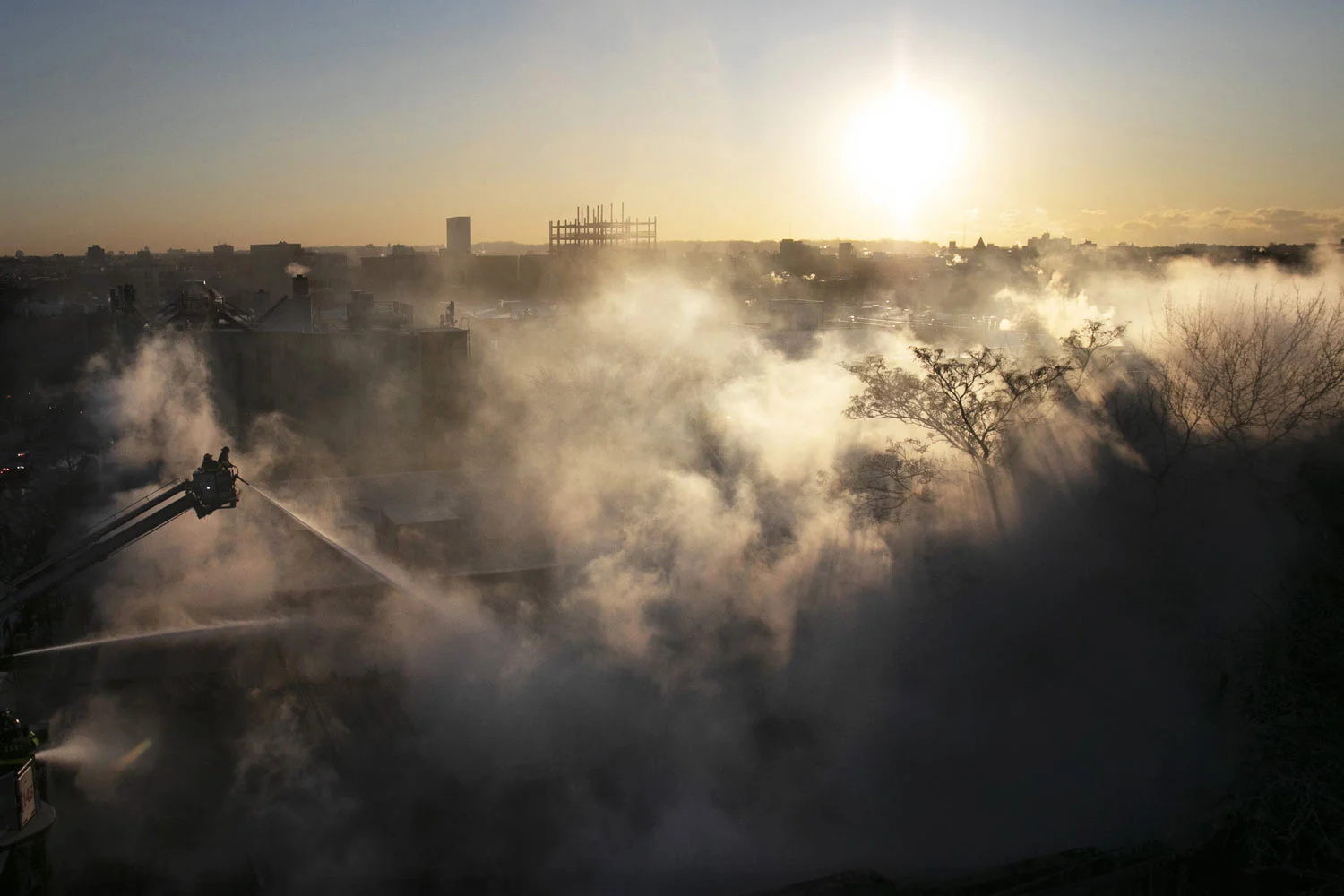 Firefighters spray water onto a burning a commercial building in the Bedford Stuyvesant neighborhood of Brooklyn, New York, on Thursday, Jan. 31, 2019 during extremely cold temperatures in the area. (AP Photo/Mark Lennihan)