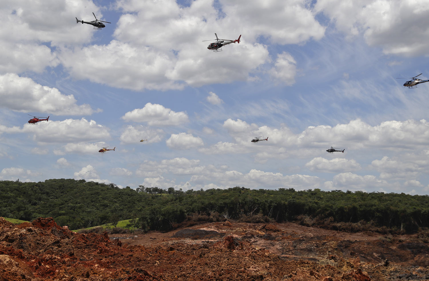 Helicopters hover over an iron ore mining complex to release thousands of flower petals paying homage to the 110 victims killed and 238 who are still missing after a mining dam collapsed there a week earlier, in Brumadinho, Brazil, Friday, Feb. 1, 2019. (AP Photo/Andre Penner)