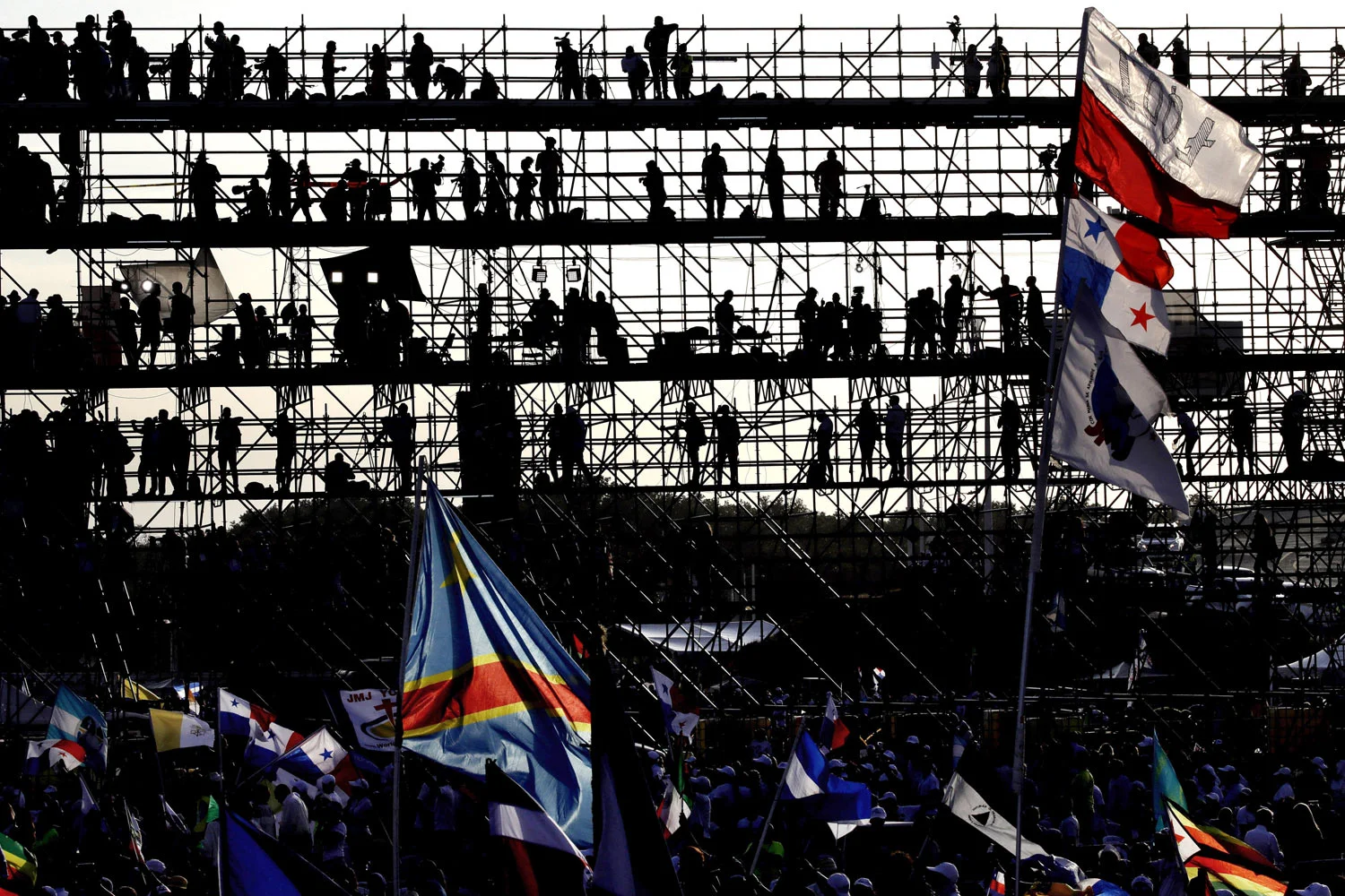 Journalists on a press stand are silhouetted against the morning sky as they and others wait for the arrival of Pope Francis to celebrate an early Mass at a park in Panama City, on Sunday, Jan. 27, 2019. The Mass marks the formal end to World Youth