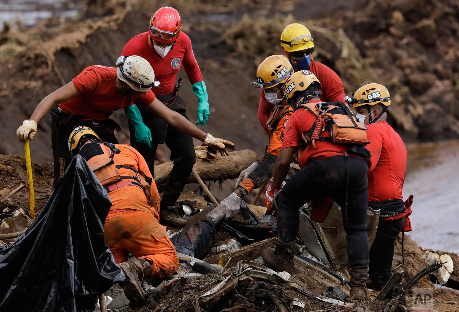 Firefighters pull a body from the mud days after the Vale mining company's dam collapsed in Brumadinho, Brazil, Jan. 28, 2019. (AP Photo/Leo Correa)