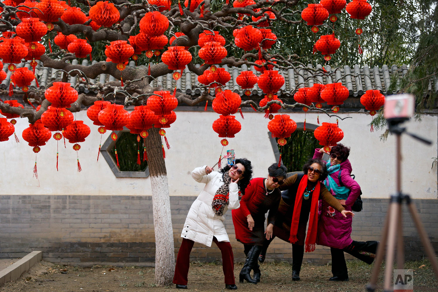  Women take a selfie near a tree decorated with red lanterns ahead of the Lunar New Year at Ditan Park in Beijing, Wednesday, Jan. 30, 2019. (AP Photo/Andy Wong) 