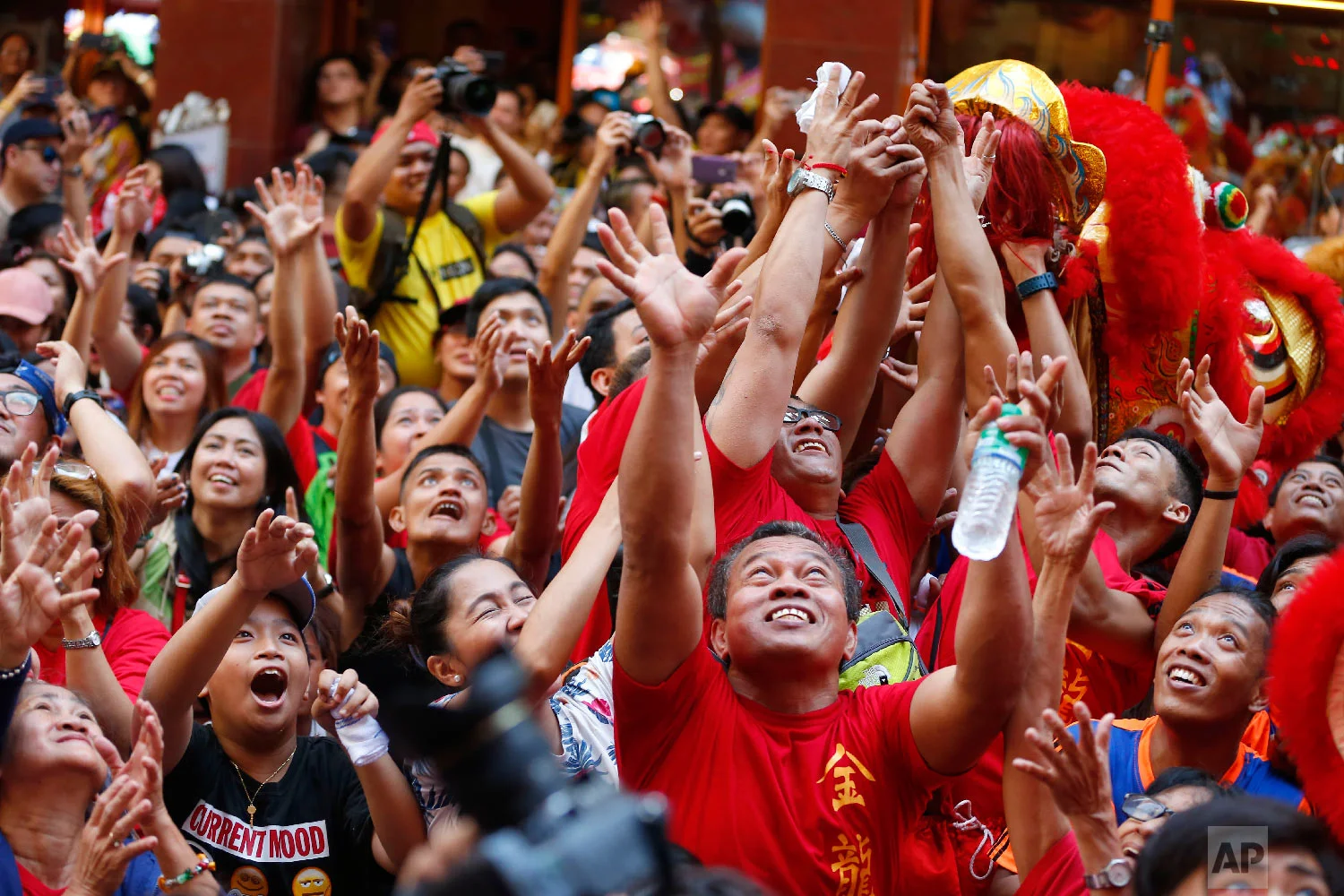 Crowds jostle to grab festive items being thrown at them during celebrations of the Lunar New Year in the Chinatown district in Manila, Philippines, Tuesday, Feb. 5, 2019. (AP Photo/Bullit Marquez)