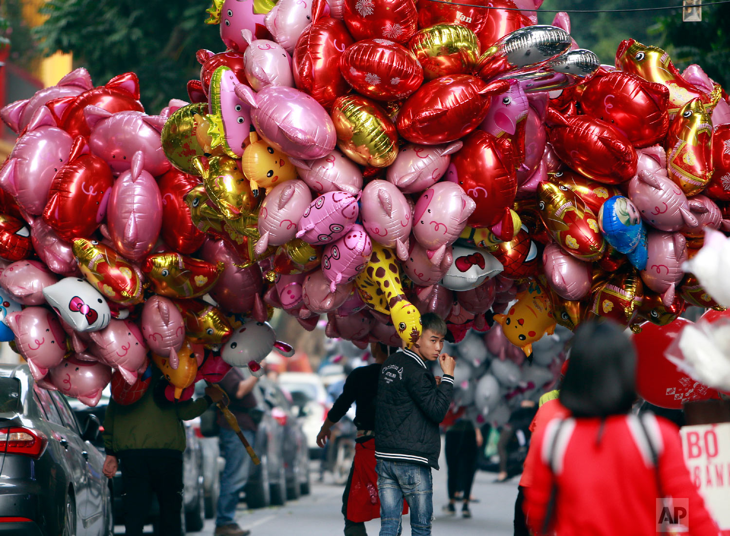  Vendors carrying pig-shaped balloons for sale to mark the Lunar New Year in Hanoi, Vietnam, Sunday, Feb. 3, 2019. (AP Photo/Hau Dinh) 