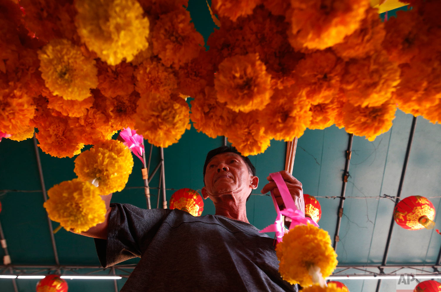  Ethnic Chinese-Thai offers flowers after prayers at the Leng Nuei Yee Chinese temple for the upcoming Lunar New Year in Bangkok, Thailand, Wednesday, Jan. 30, 2019. (AP Photo/Sakchai Lalit) 