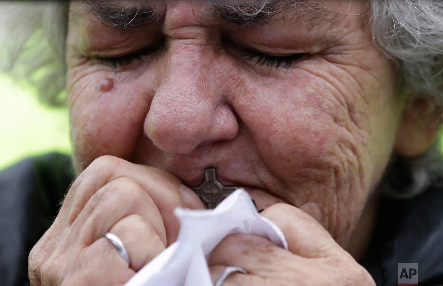 A woman kisses a cross during a rally to protest terrorism in Bogota, Colombia, Jan. 20, 2019. A car bombing at a Bogota police academy that authorities have attributed to rebels of the National Liberation Army killed 21 people and left dozens more wounded on Jan. 17. (AP Photo/Fernando Vergara)