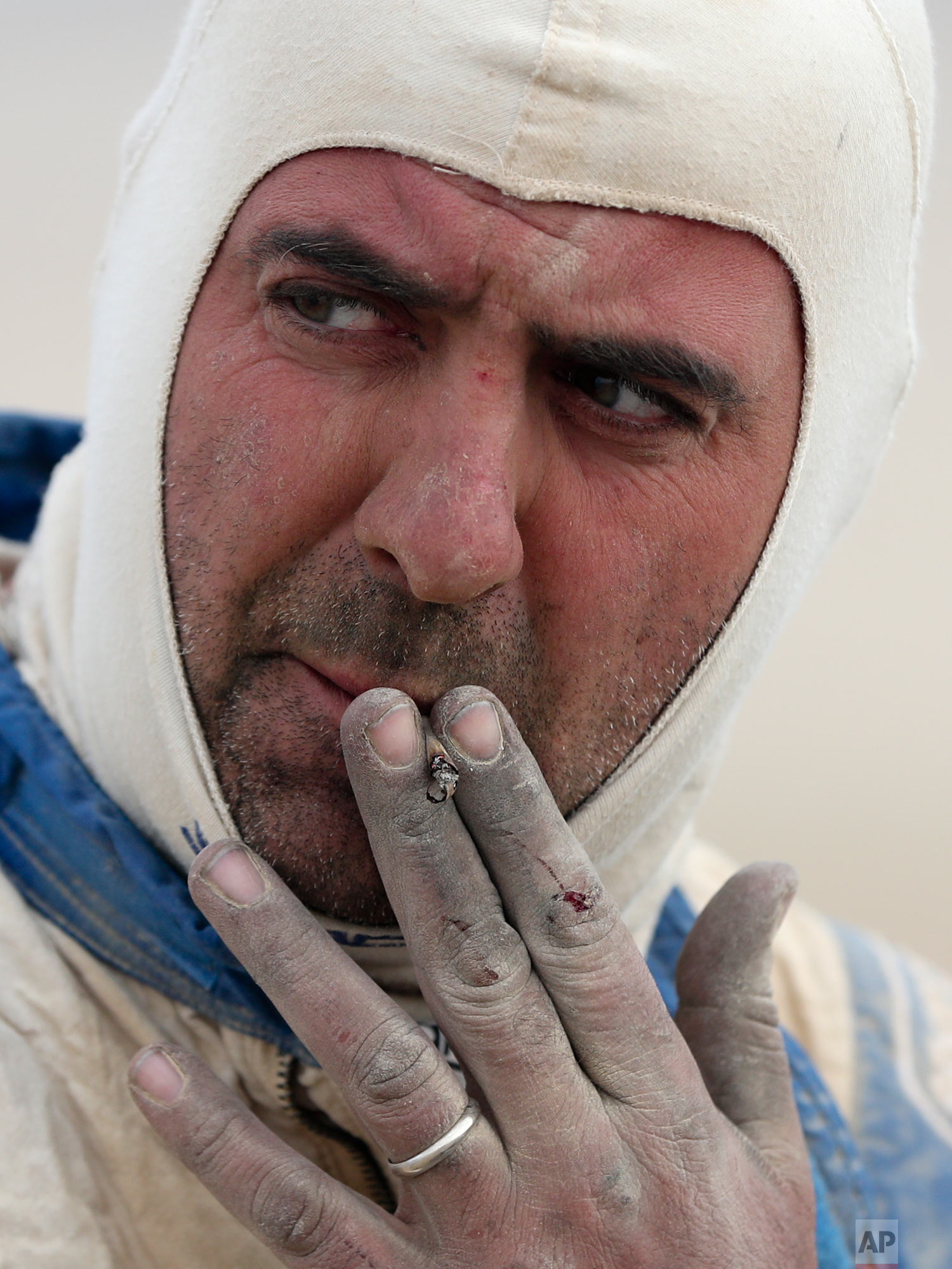  Italian co-driver Angelo Montico smokes as he competes in stage eight of the Dakar Rally, between San Juan de Marcona and Pisco, Peru, Jan. 15, 2019. (AP Photo/Ricardo Mazalan) 