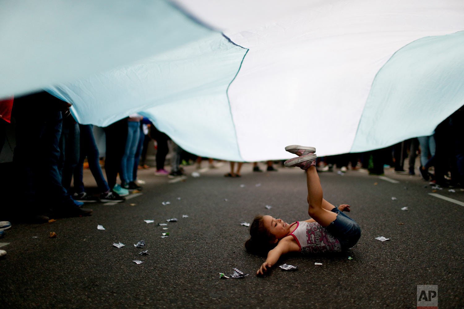  A girl plays under an Argentine flag as demonstrators protest the increase in public service fees in Buenos Aires, Argentina, Jan. 10, 2019. (AP Photo/Natacha Pisarenko) 