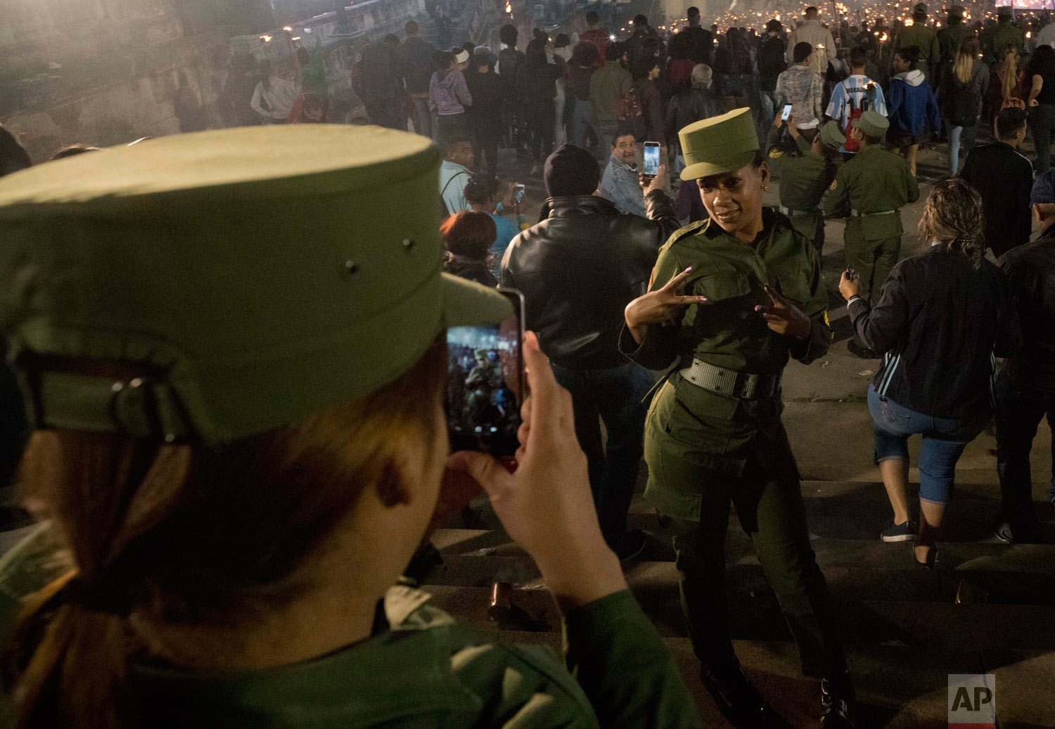 Cuban soldiers take pictures of themselves during the march of torches marking the 166th anniversary of the birth of Cuba's national independence hero Jose Marti and to pay tribute to late revolutionary leader Fidel Castro, in Havana, Cuba, Jan. 28,