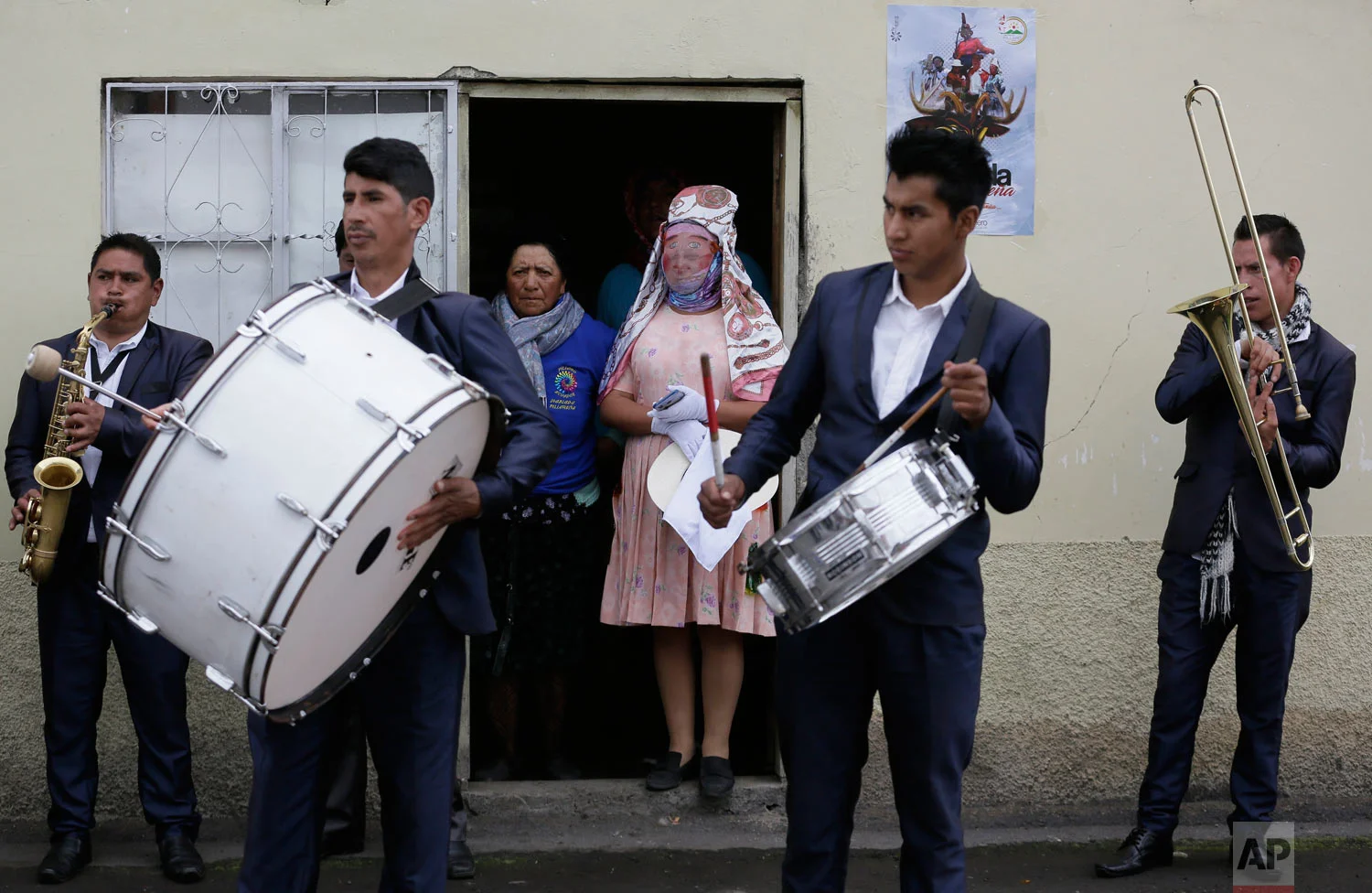 Musicians and a reveler in costume get ready to participate in the feast of "La Diablada" in Pillaro, Ecuador, Jan. 4, 2019. (AP Photo/Dolores Ochoa)