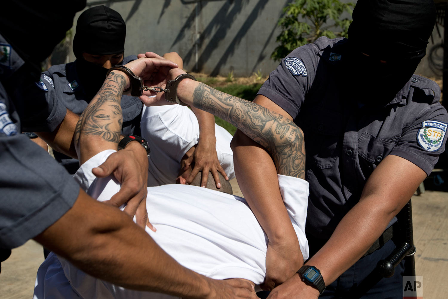  Jailed men identified by authorities as members of the Mara Salvatrucha gang are escorted in handcuffs by masked prison guards to the Zacatras high security prison where they will await trials for murder in Zacatecoluca, El Salvador, Jan. 31, 2019. 