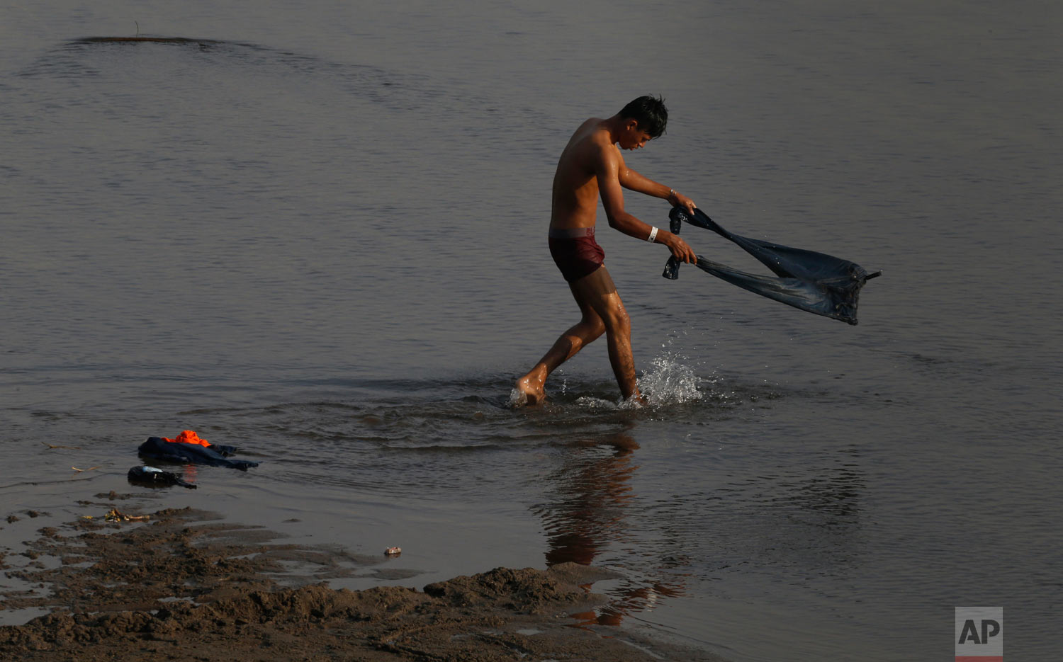  A Central American migrant awaiting a humanitarian visa from Mexico washes his pants in the Suchiate River, the natural the border between Mexico and Guatemala, on the riverbank near Ciudad Hidalgo, Chiapas state, Mexico, Jan. 20, 2019. (AP Photo/Ma