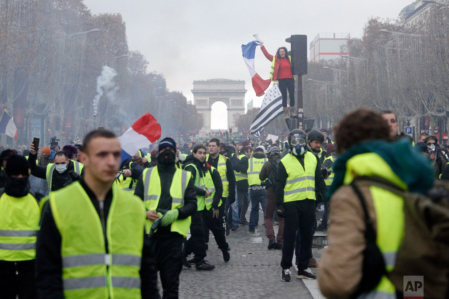 Demonstrators, called the yellow jackets, march on the famed Champs-Elysees avenue in Paris, France, as they protest against the rising of the fuel prices, Nov. 24, 2018. (AP Photo/Kamil Zihnioglu)