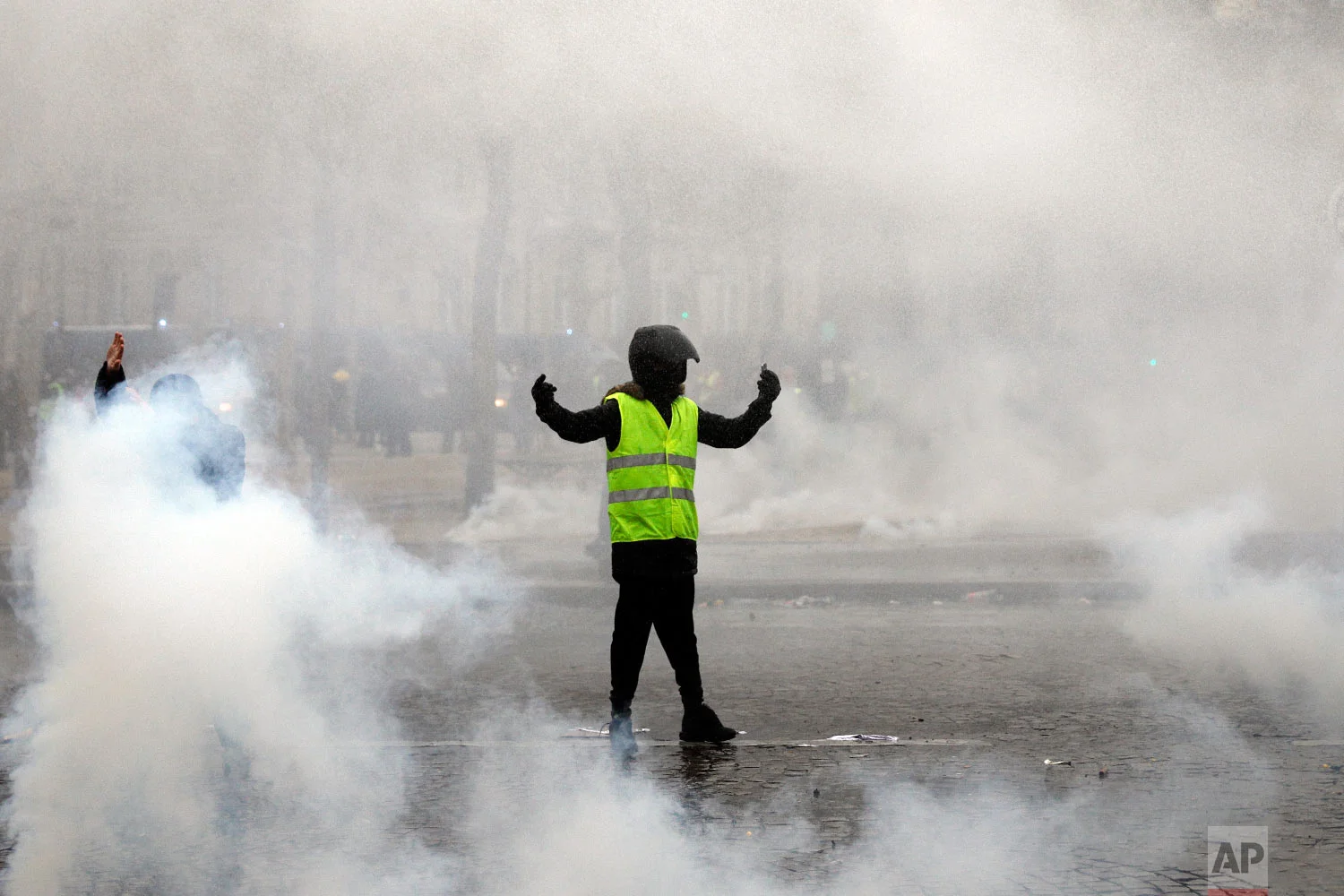 A yellow vest protester taunts riot police during clashes around the Arc of Triomphe in Paris, France, Jan. 12, 2019. (AP Photo/Kamil Zihnioglu)