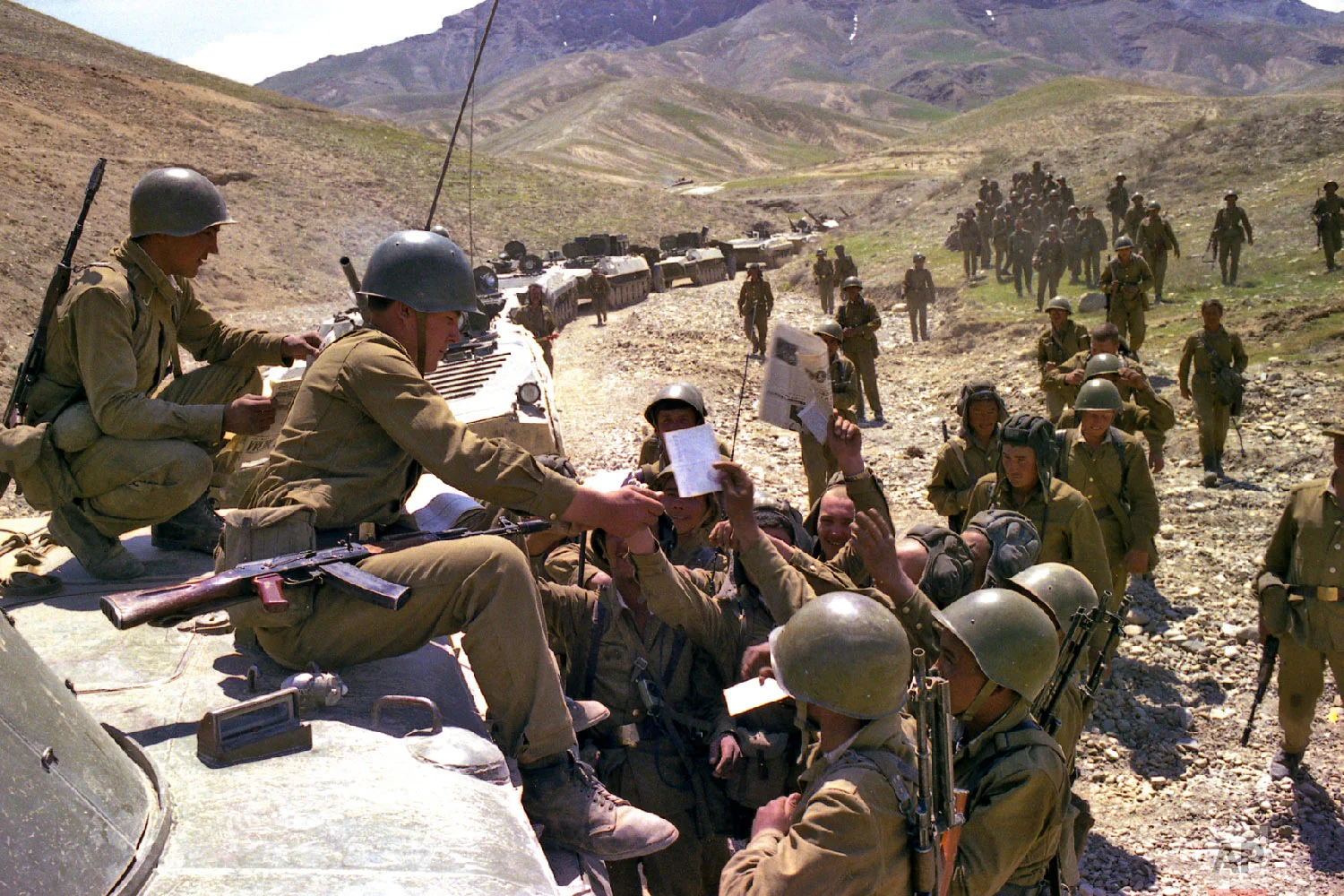 Soviet soldiers get fresh newspapers and mail while a convoy stoped somewhere in Afghanistan. (Leonid Yakutin/Defense Ministry Press Service via AP)