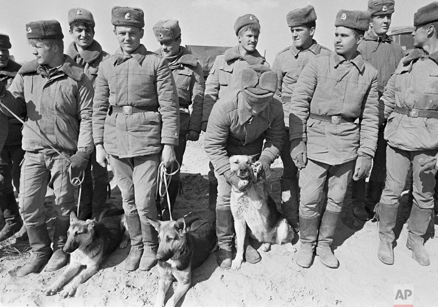 Soviet Army soldiers with their war-dogs line up after their unit crossed a bridge on the border between Afghanistan and then Soviet Uzbekistan near the Uzbek town of Termez, Uzbekistan on Feb. 15, 1989. (AP Photo/Alexander Zemlianichenko)