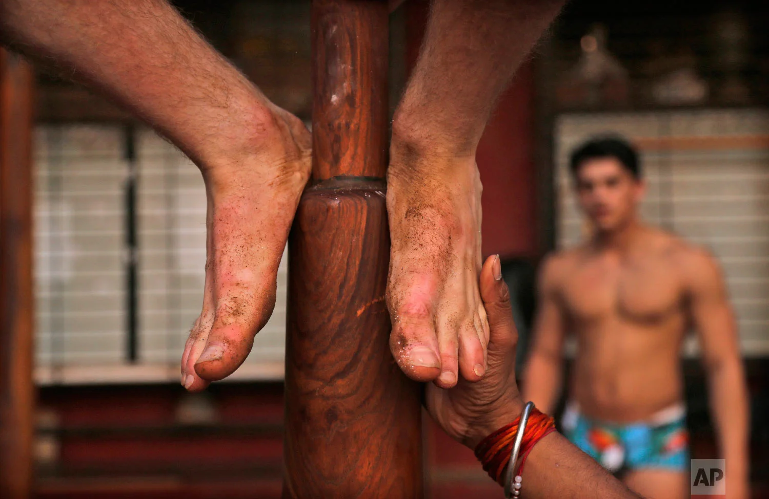 A trainer helps Alfie Meeson of Newcastle, England, on a mallakhamb pole at Shivaji Park on Feb. 5, 2019, in Mumbai, India. (AP Photo/Rafiq Maqbool)