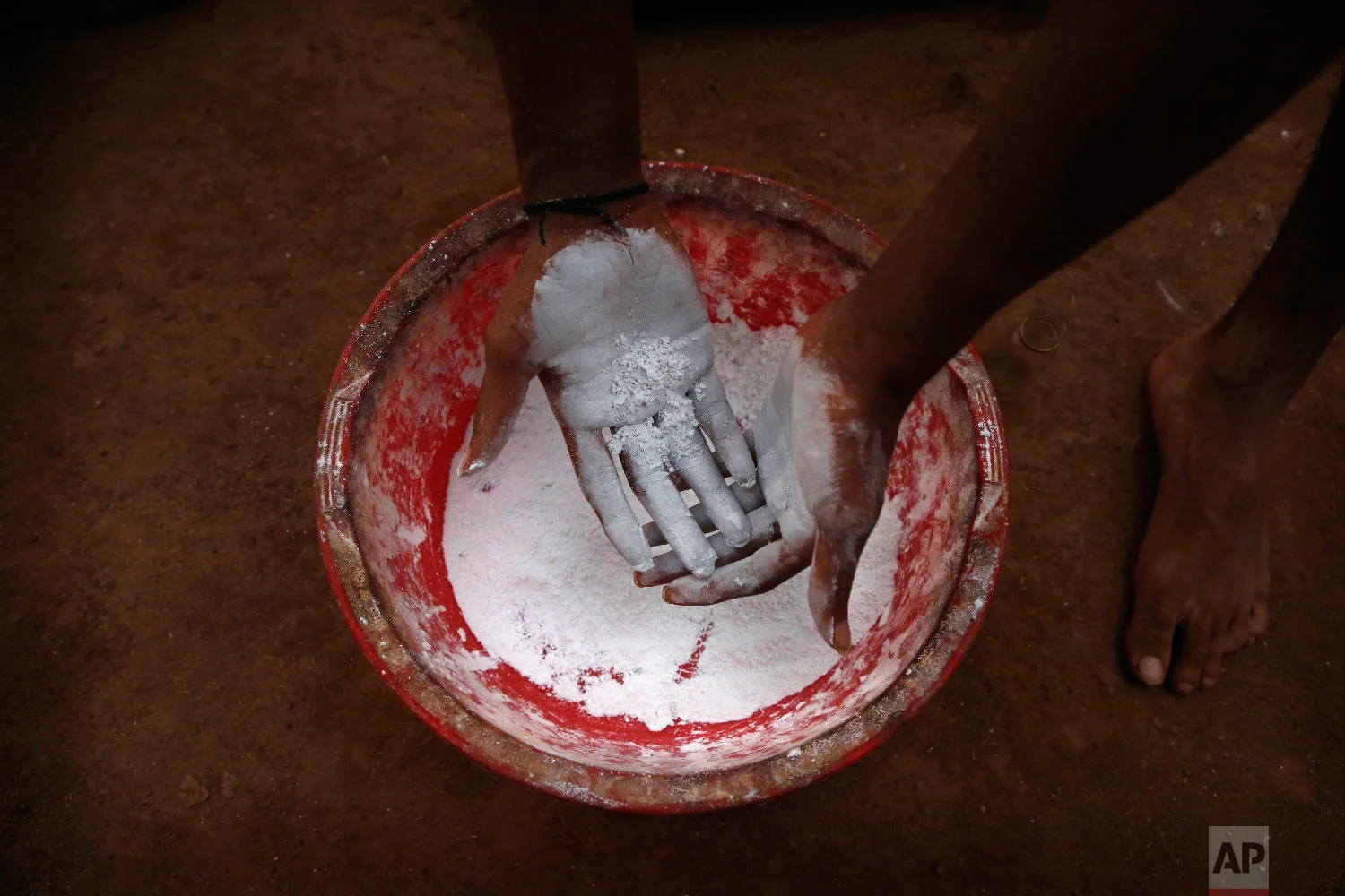 A player powders his hands before performing on a mallakhamb pole at Shivaji Park on Feb. 5, 2019, in Mumbai, India. (AP Photo/Rafiq Maqbool)
