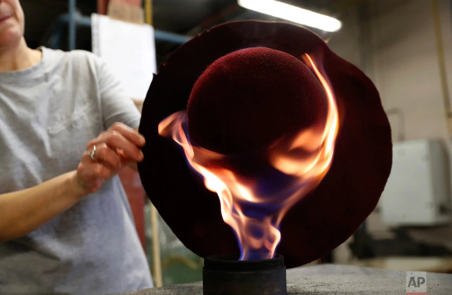 A woman works on a hat in Borsalino's hat factory, in Spinetta Marengo, near Alessandria, Italy, Thursday, Jan. 17, 2019. (AP Photo/Antonio Calanni)