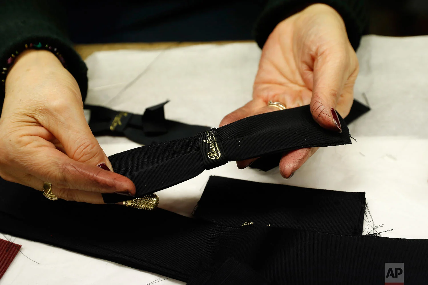 A woman shows a label inside the Borsalino hat factory in Spinetta Marengo, near Alessandria, Italy, Thursday, Jan. 17, 2019. (AP Photo/Antonio Calanni)