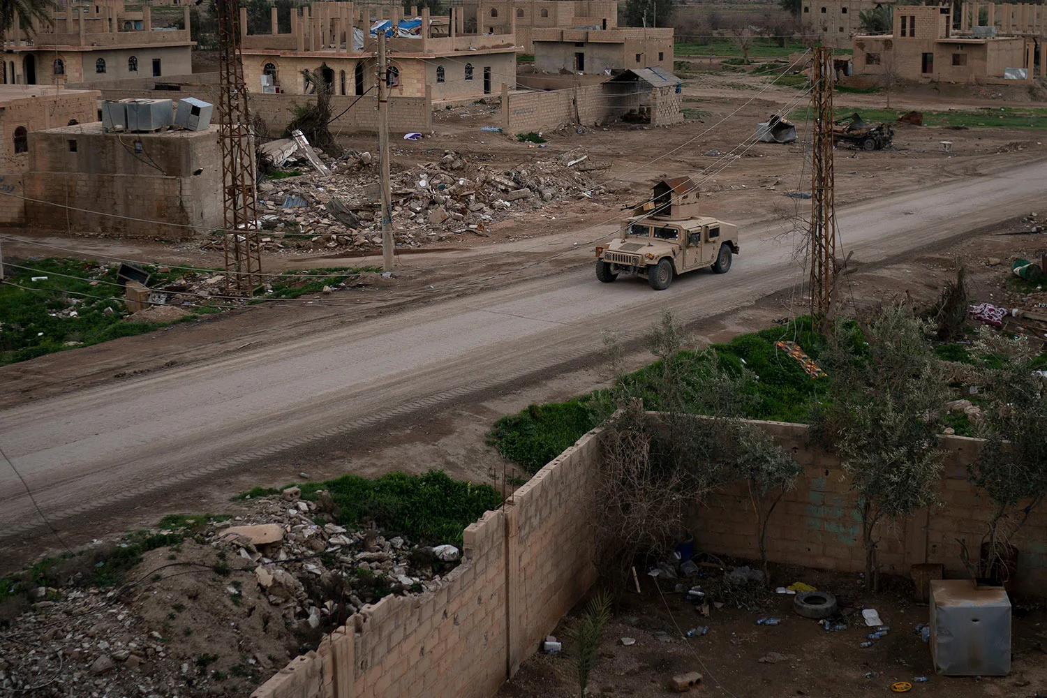 A Humvee drives in a village recently retaken from Islamic State militants by U.S.-backed Syrian Democratic Forces (SDF) near Baghouz, Syria, Sunday, Feb. 17, 2019. Islamic State militants are preventing more than 1,000 civilians from leaving a tiny area still held by the extremist group in a village in eastern Syria, a spokesman for the U.S.-backed Syrian militia fighting the group said Sunday. (AP Photo/Felipe Dana)