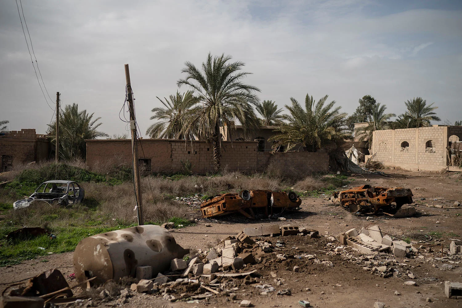 Damaged cars sit in an area recently retaken by U.S.-backed Syrian Democratic Forces (SDF) from Islamic State militants in Susah, Syria, Saturday, Feb. 16, 2019. (AP Photo/Felipe Dana)