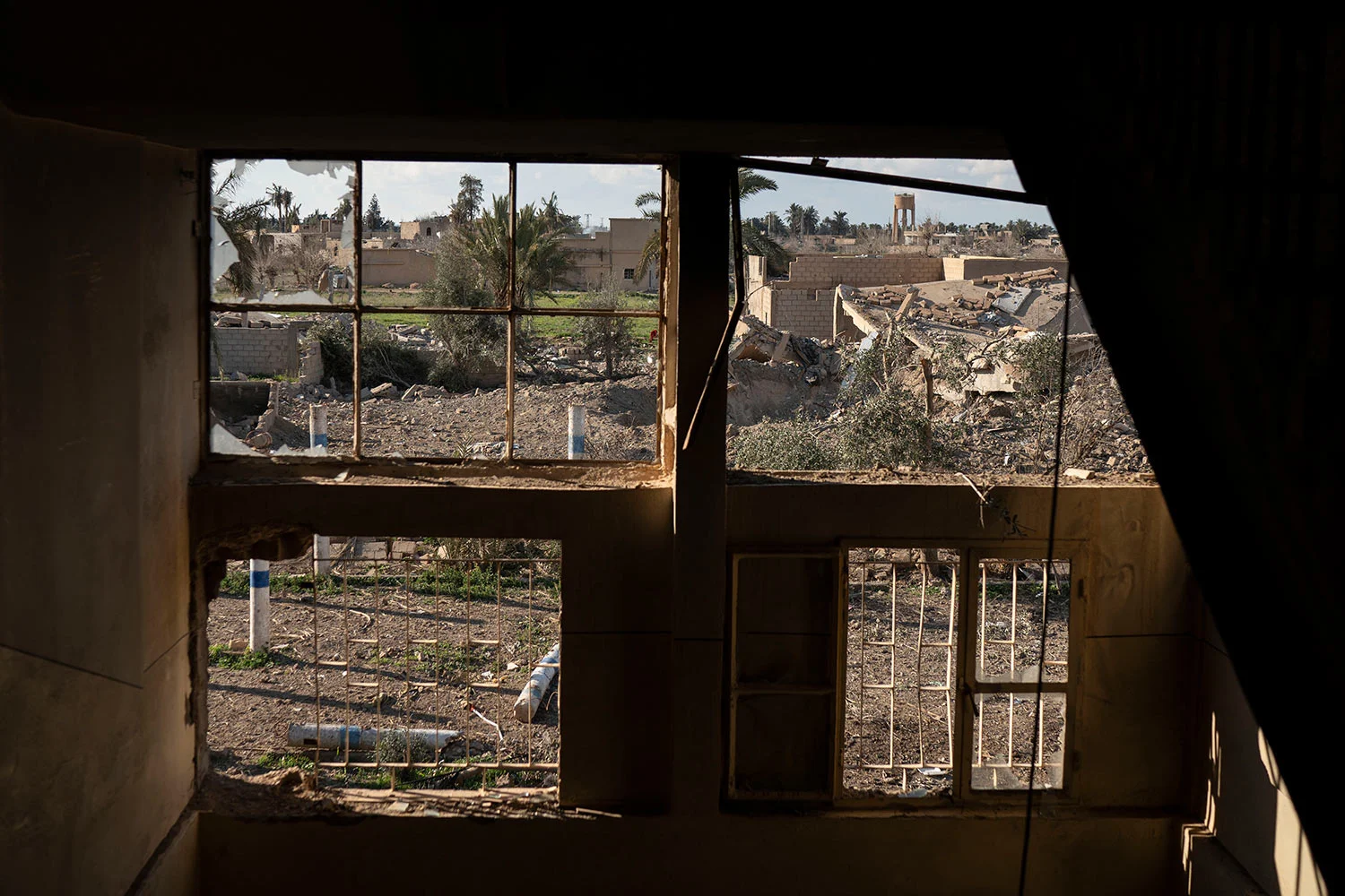 Destroyed homes are framed by damaged windows in a building taken by U.S.-backed Syrian Democratic Forces (SDF) near the last land still held by Islamic State militants in Baghouz, Syria, Monday, Feb. 18, 2019. (AP Photo/Felipe Dana)