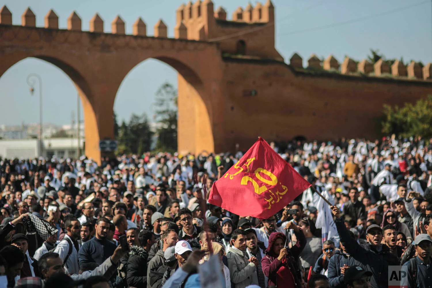 Teachers wave a flag commemorating the Feb. 20 Moroccan Arab Spring movement, during a demonstration in Rabat, Morocco, Feb. 20, 2019. (AP Photo/Mosa'ab Elshamy)