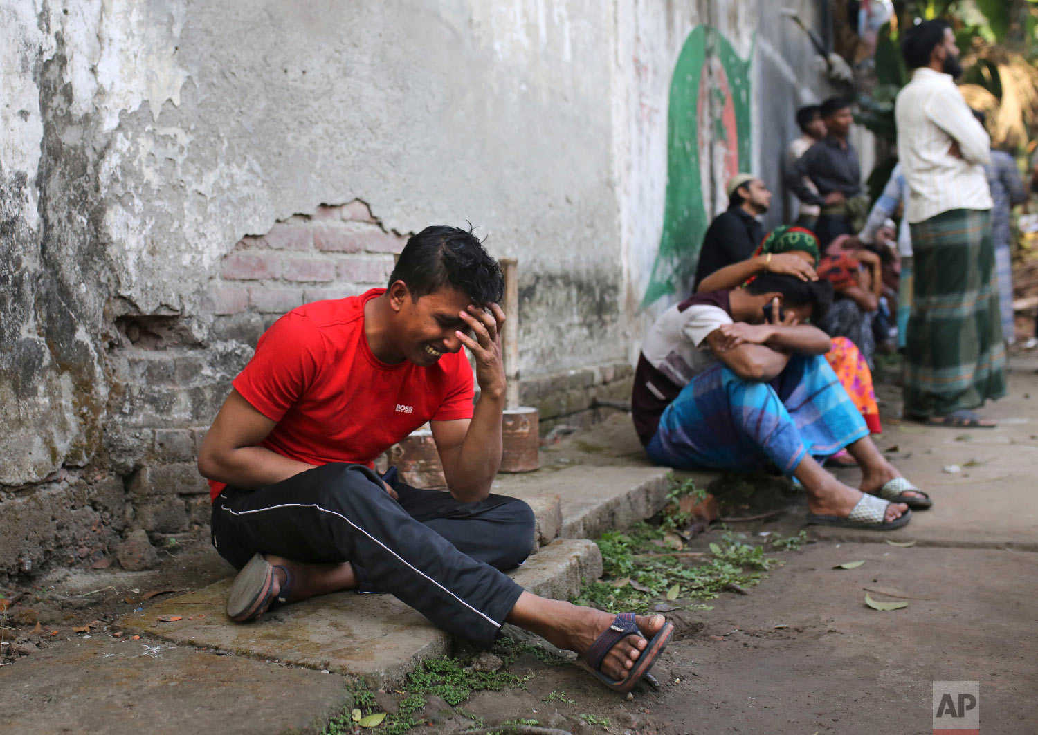 An unidentified Bangladeshi cries by the site of a fire that broke out late Wednesday in closely set buildings in Dhaka, Bangladesh, Thursday, Feb. 21, 2019. (AP Photo/Rehman Asad)
