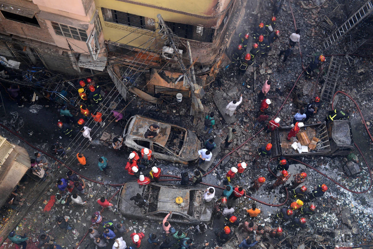 Rescuers stand at the site of a late Wednesday night fire in Dhaka, Bangladesh, Thursday, Feb. 21, 2019. (AP Photo/Mahmud Hossain Opu)