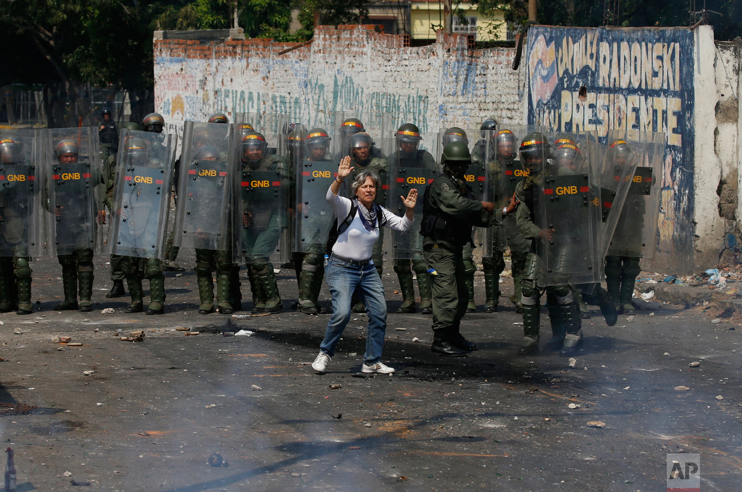 A demonstrator tries to stop the violence as she stands in front of a line of Venezuelan Bolivarian National Guard officers during clashes in Urena, Venezuela, near the border with Colombia, Saturday, Feb. 23, 2019. (AP Photo/Fernando Llano)