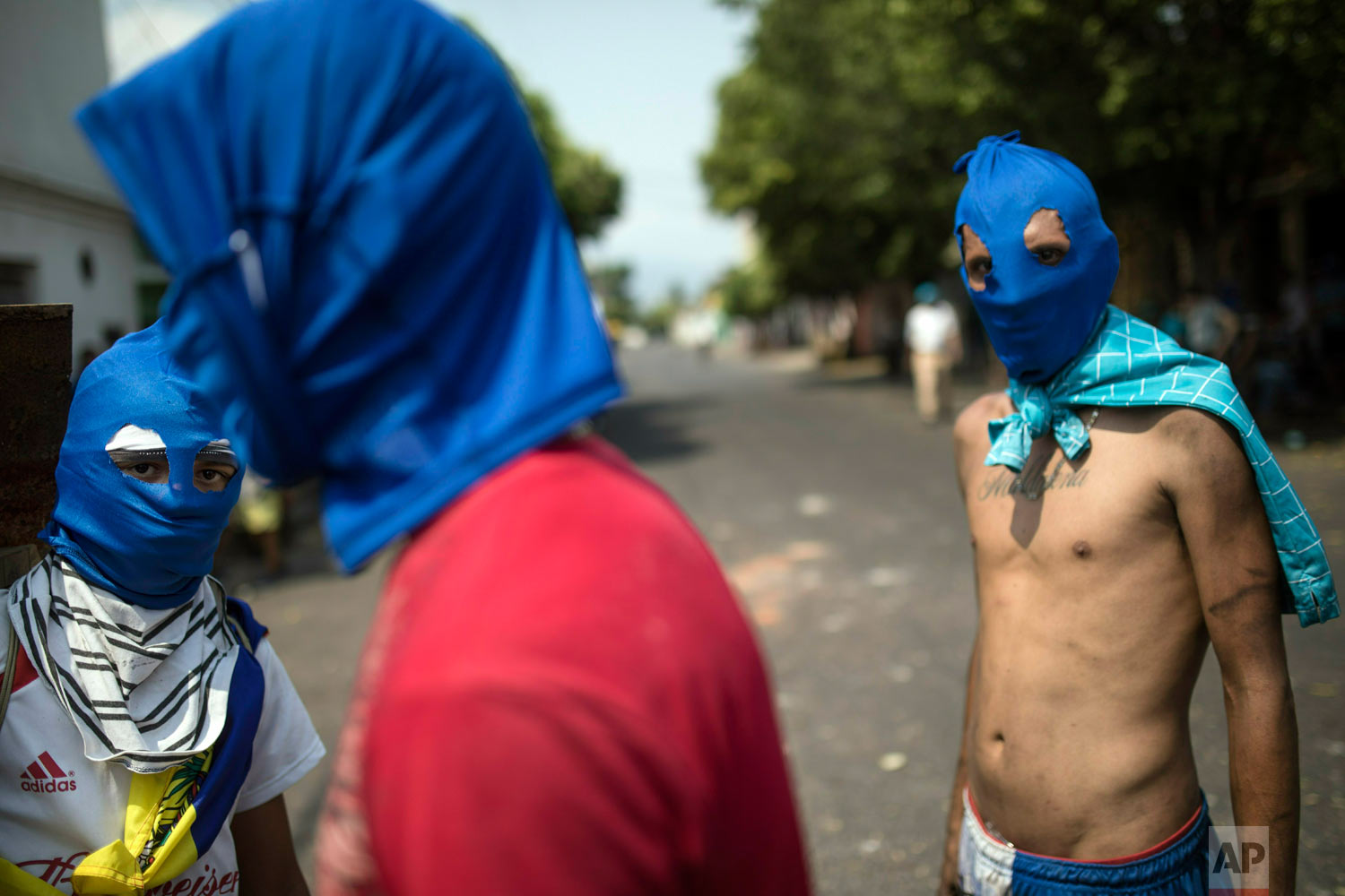  Masked anti-government protesters gather a few blocks from the border bridge in Urena, Venezuela, Sunday, Feb. 24, 2019, where Venezuelan soldiers continue to block humanitarian aid from entering. (AP Photo/Rodrigo Abd) 