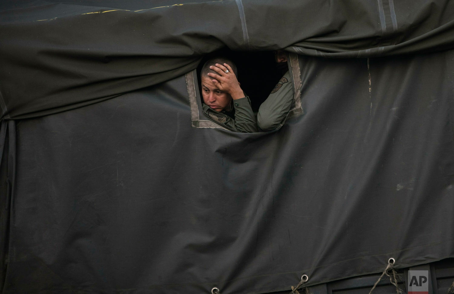  Bolivarian National Guards sit inside a truck at the entrance of the Tienditas International bridge that connects Venezuela with Colombia, in Urena, Venezuela, Feb. 21, 2019. (AP Photo/Rodrigo Abd) 