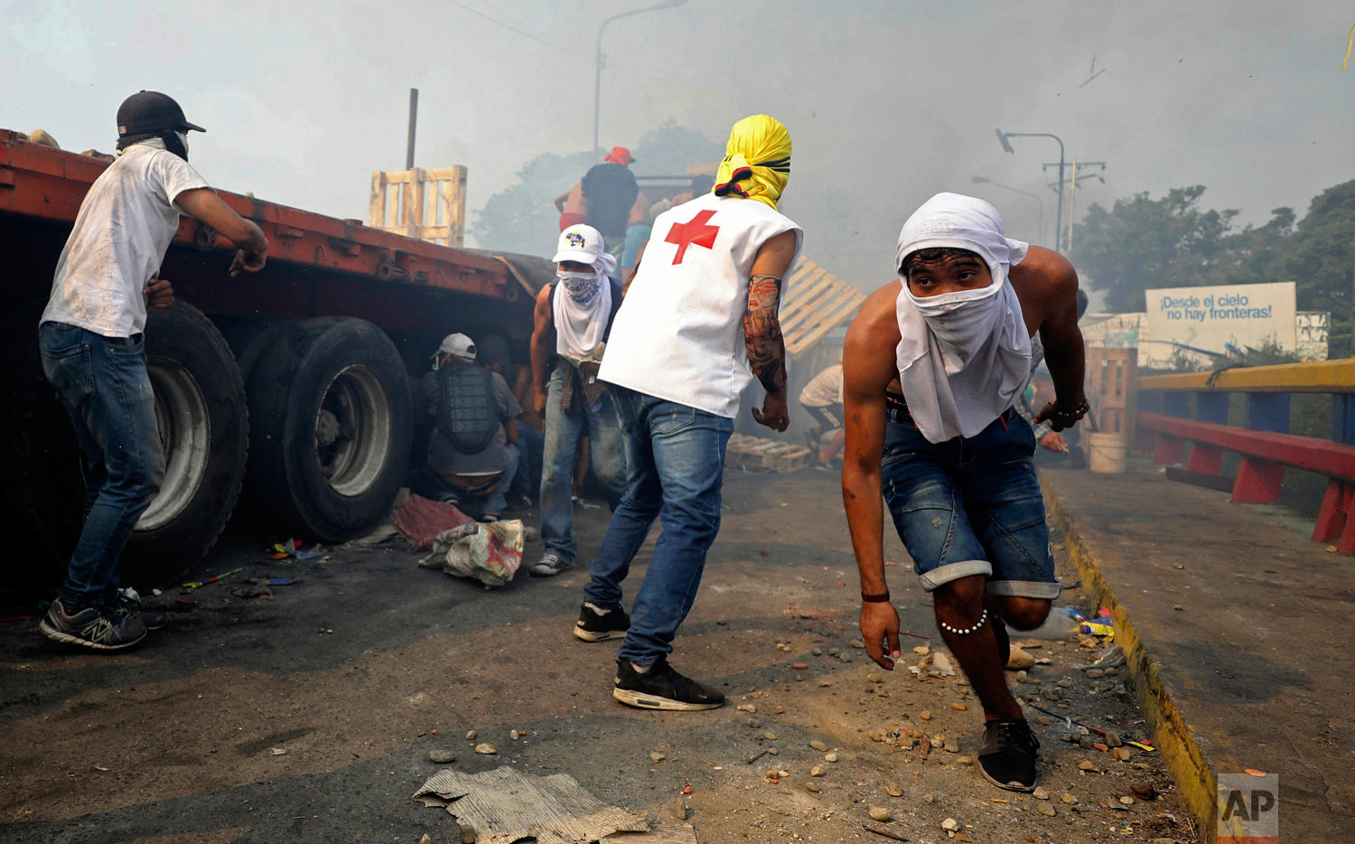  Venezuelan youth clash with  Venezuelan National Guard next to a semi-trailer that was part of a humanitarian aid convoy that failed to cross the Francisco de Paula Santander international bridge in Cucuta, Colombia, Saturday, Feb. 23, 2019. (AP Pho