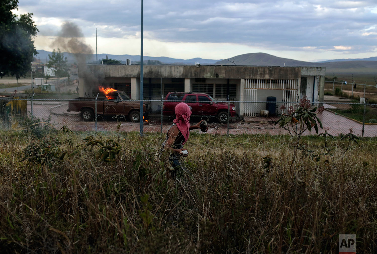  A demonstrator throws a stone at a Venezuelan military post at the border between Brazil and Venezuela, in Pacaraima, Roraima state, Brazil, Saturday, Feb.23, 2019. (AP Photo/Ivan Valencia) 