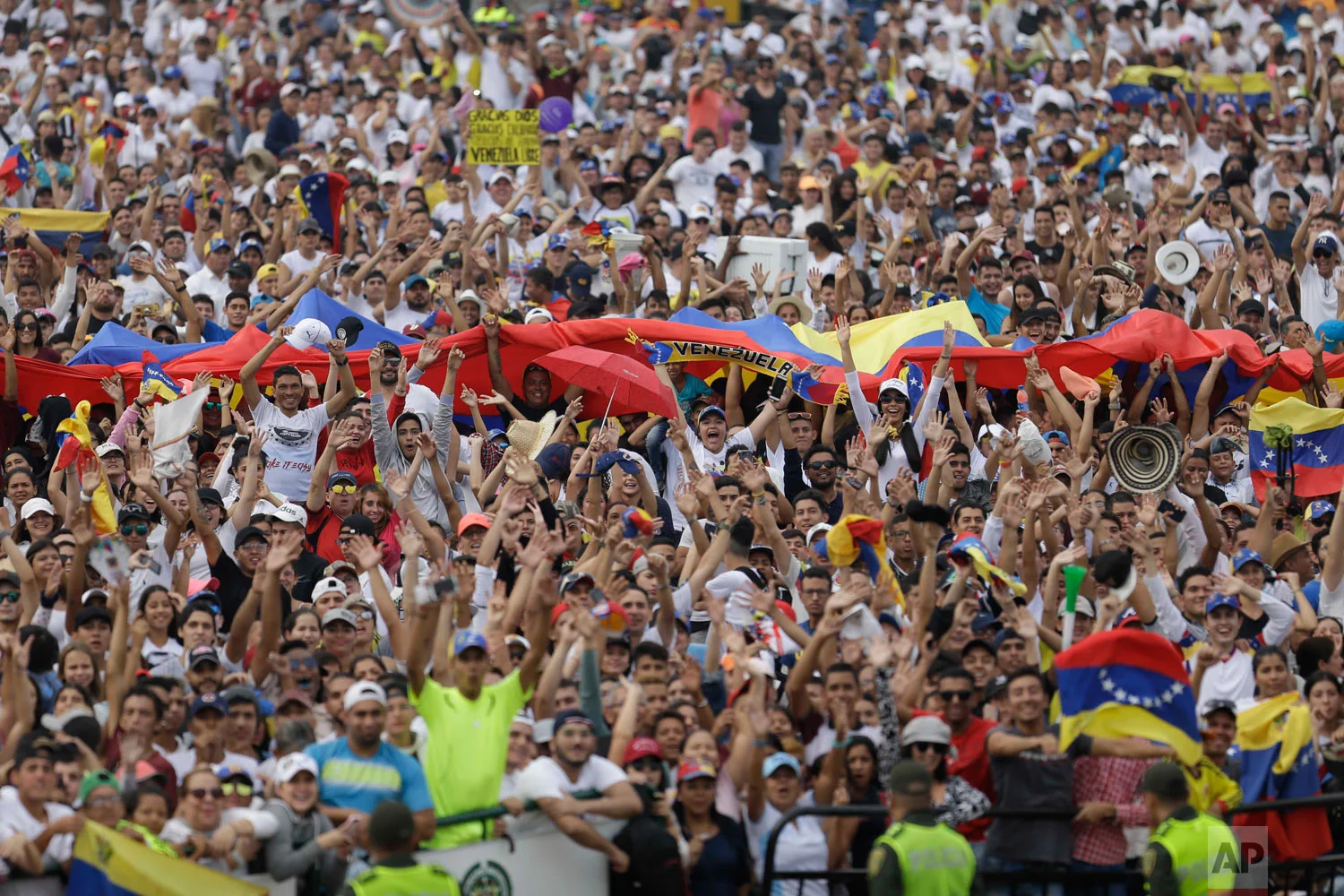 People begin to fill the Venezuela Aid Live concert on the Colombian side of the Tienditas International Bridge on the outskirts of Cucuta, Colombia, on the border with Venezuela, Friday, Feb. 22, 2019. (AP Photo/Fernando Vergara)