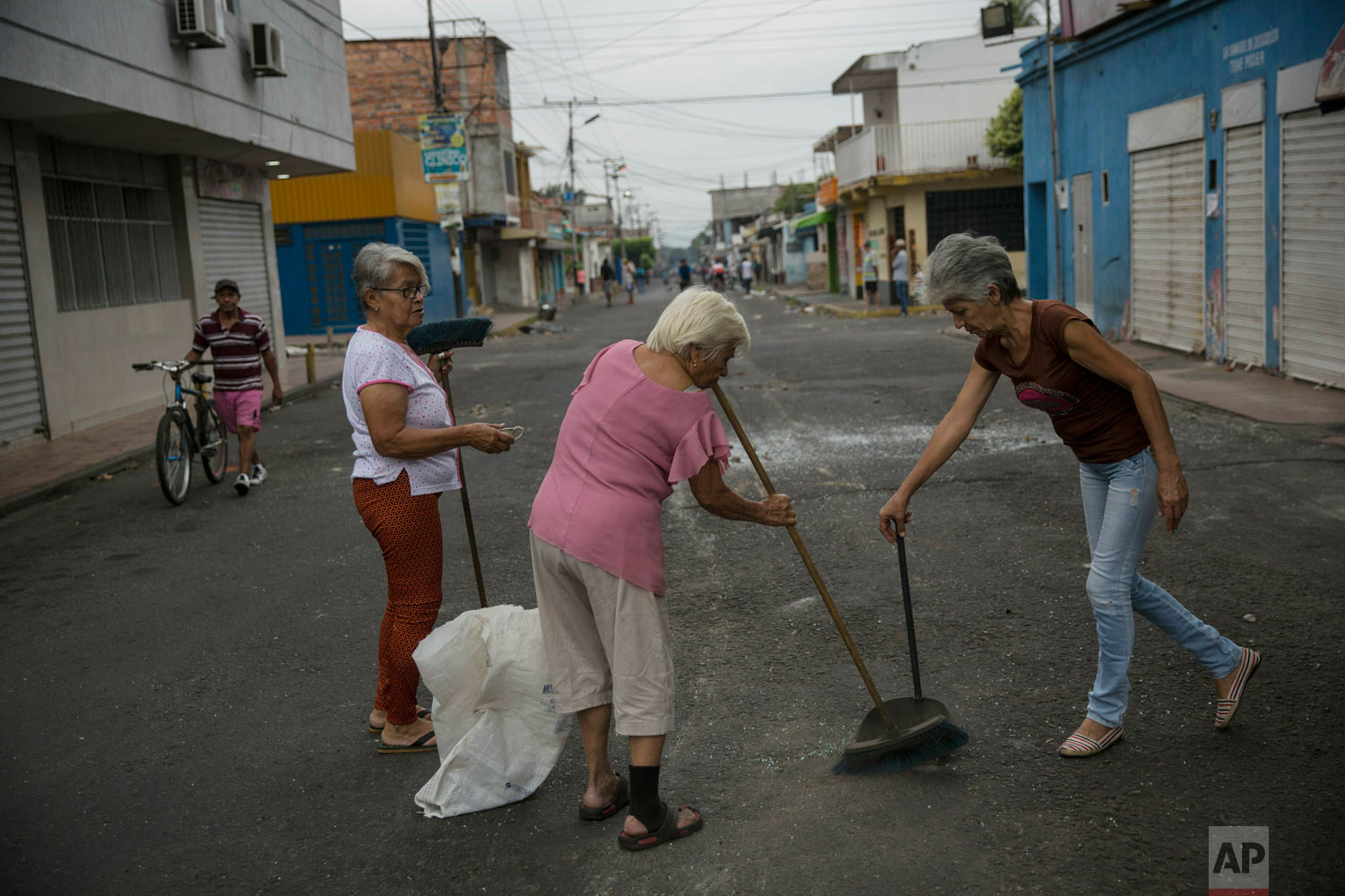  Neighbors clean the streets a day after clashes between anti-government protesters and the Venezuelan Bolivarian National Guard in Urena, Venezuela, near the border with Colombia, Sunday, Feb. 24, 2019. (AP Photo/Rodrigo Abd) 