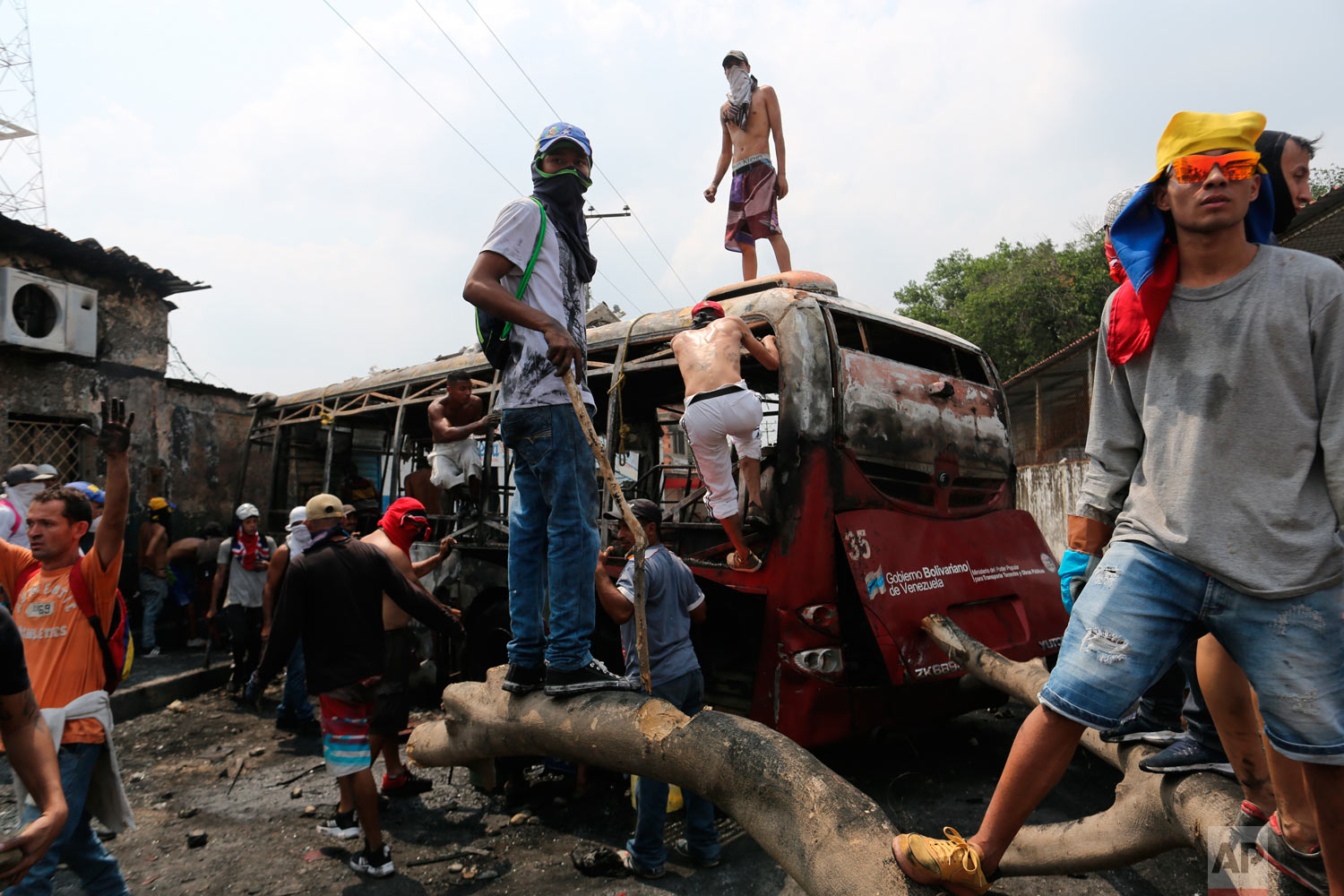  Demonstrators stand on a torched bus during clashes with the Venezuelan Bolivarian National Guard in Urena, Venezuela, near the border with Colombia, Saturday, Feb. 23, 2019. (AP Photo/Rodrigo Abd) 