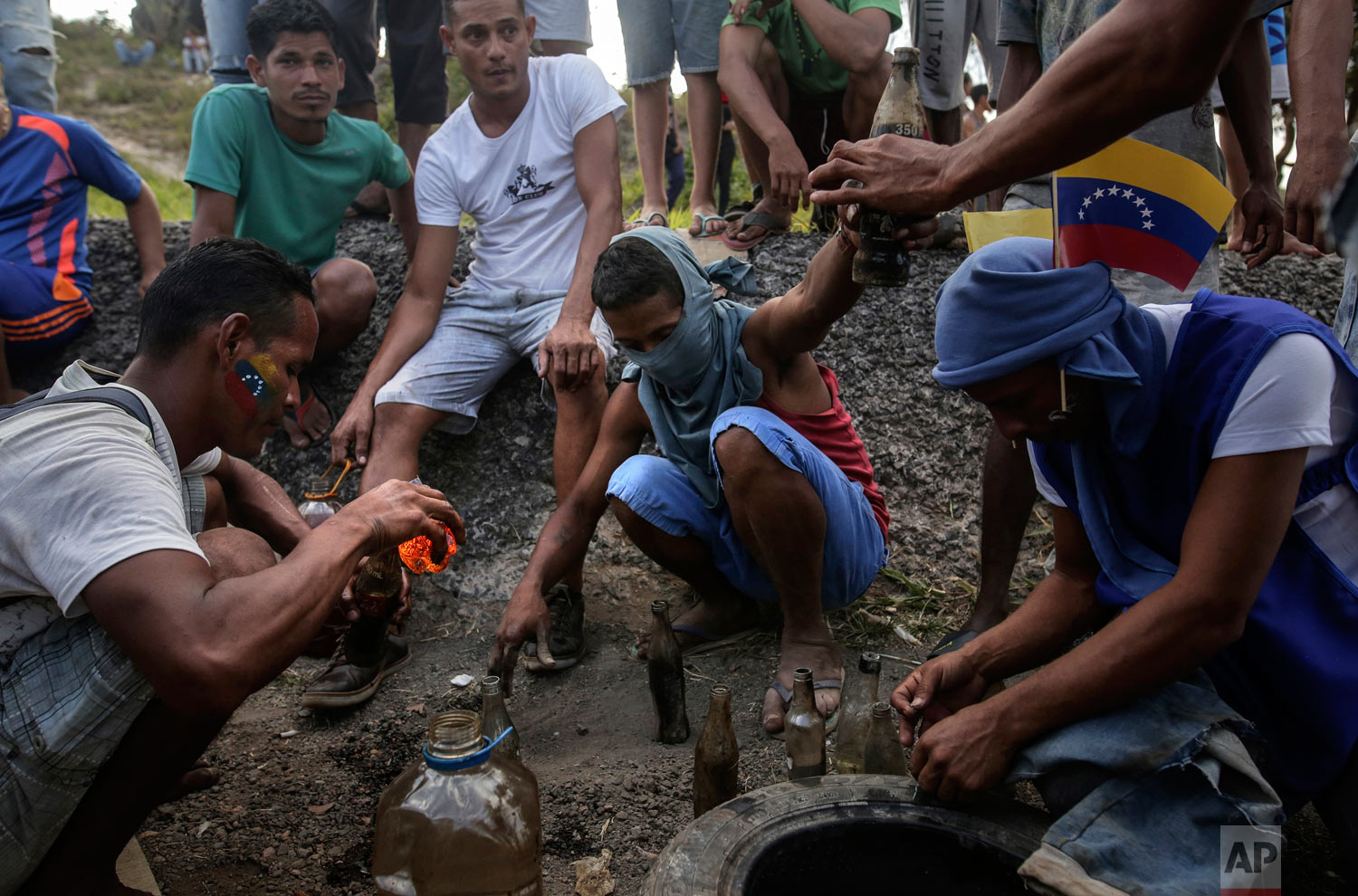 Demonstrators prepare gasoline bombs during a protest at the border between Brazil and Venezuela, in Pacaraima, Roraima state, Brazil, Saturday, Feb.23, 2019. (AP Photo/Ivan Valencia)