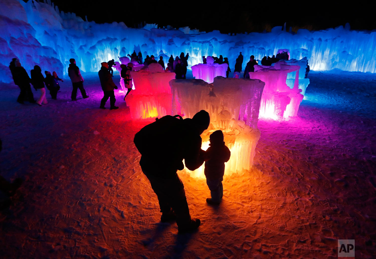 Bruce McCafferty and his son, Dougie, pause while explore the ice formations growing at Ice Castles, in North Woodstock, N.H., on Jan. 26, 2019. (AP Photo/Robert F. Bukaty)