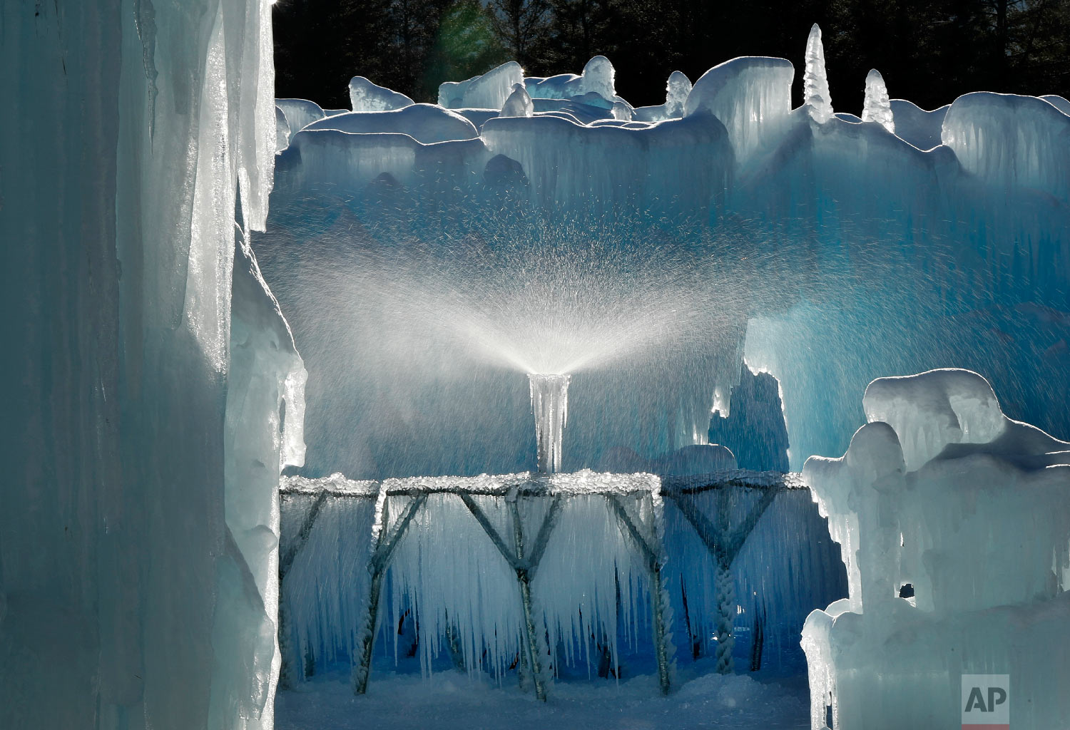 A sprinkler sprays a fine mist over a metal rack to grow icicles in North Woodstock, N.H., Jan. 28, 2019. (AP Photo/Robert F. Bukaty)