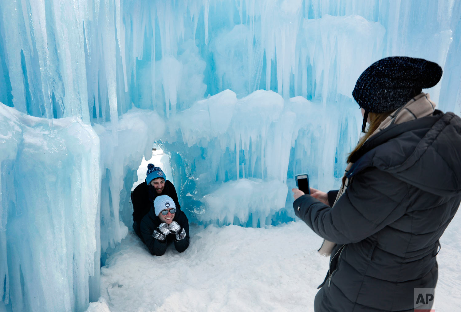 Visitors pose for a photo in a tunnel at Ice Castles Jan. 26, 2019, in North Woodstock, N.H. (AP Photo/Robert F. Bukaty)
