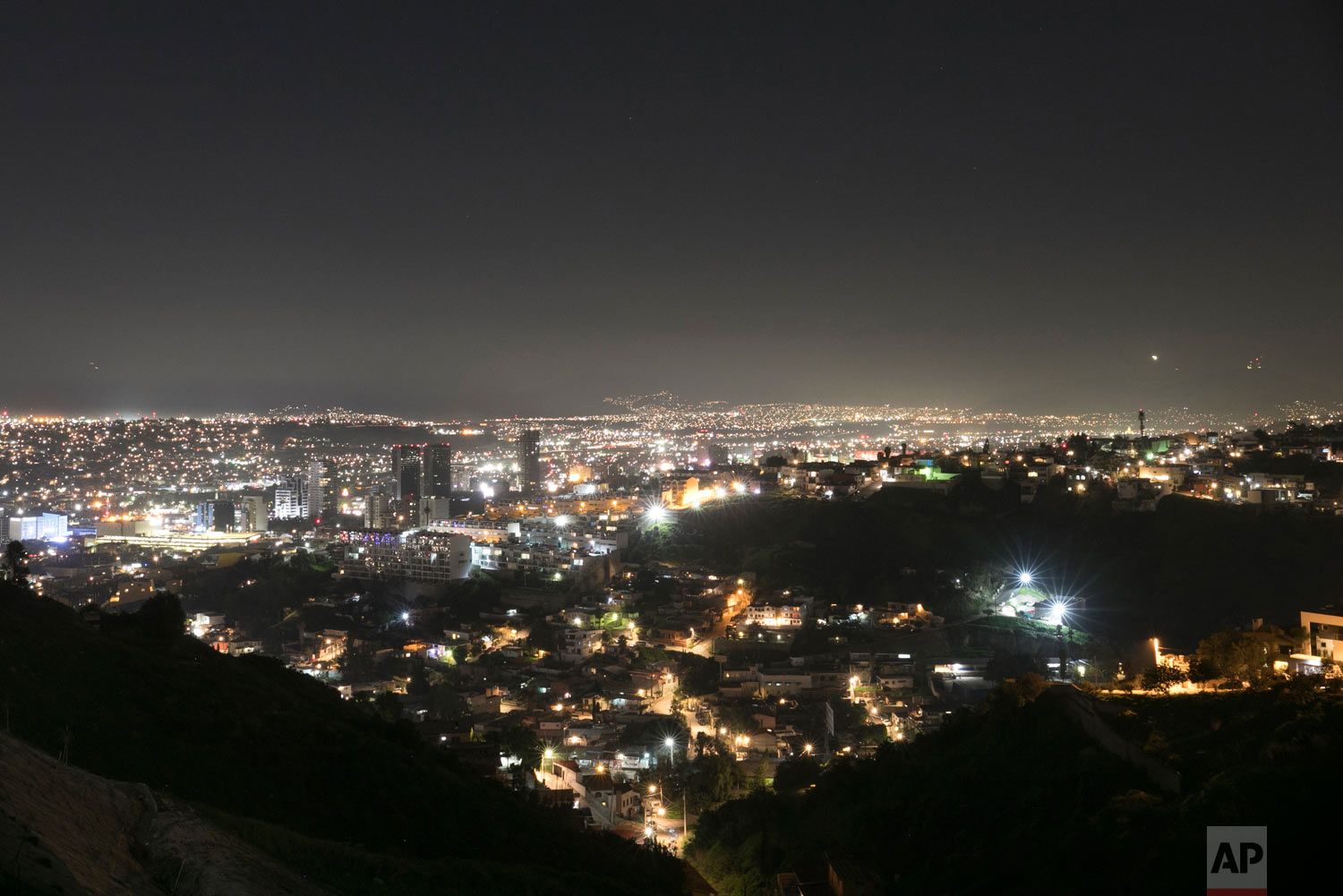  Lights twinkle at night in Tijuana, Mexico, Feb. 7, 2019. El Salvador teen migrant sisters Milagro de Jesus Henriquez Ayala and Xiomara say they are too afraid to cross the border illegally after seeing the towering wall topped with concertina wire,